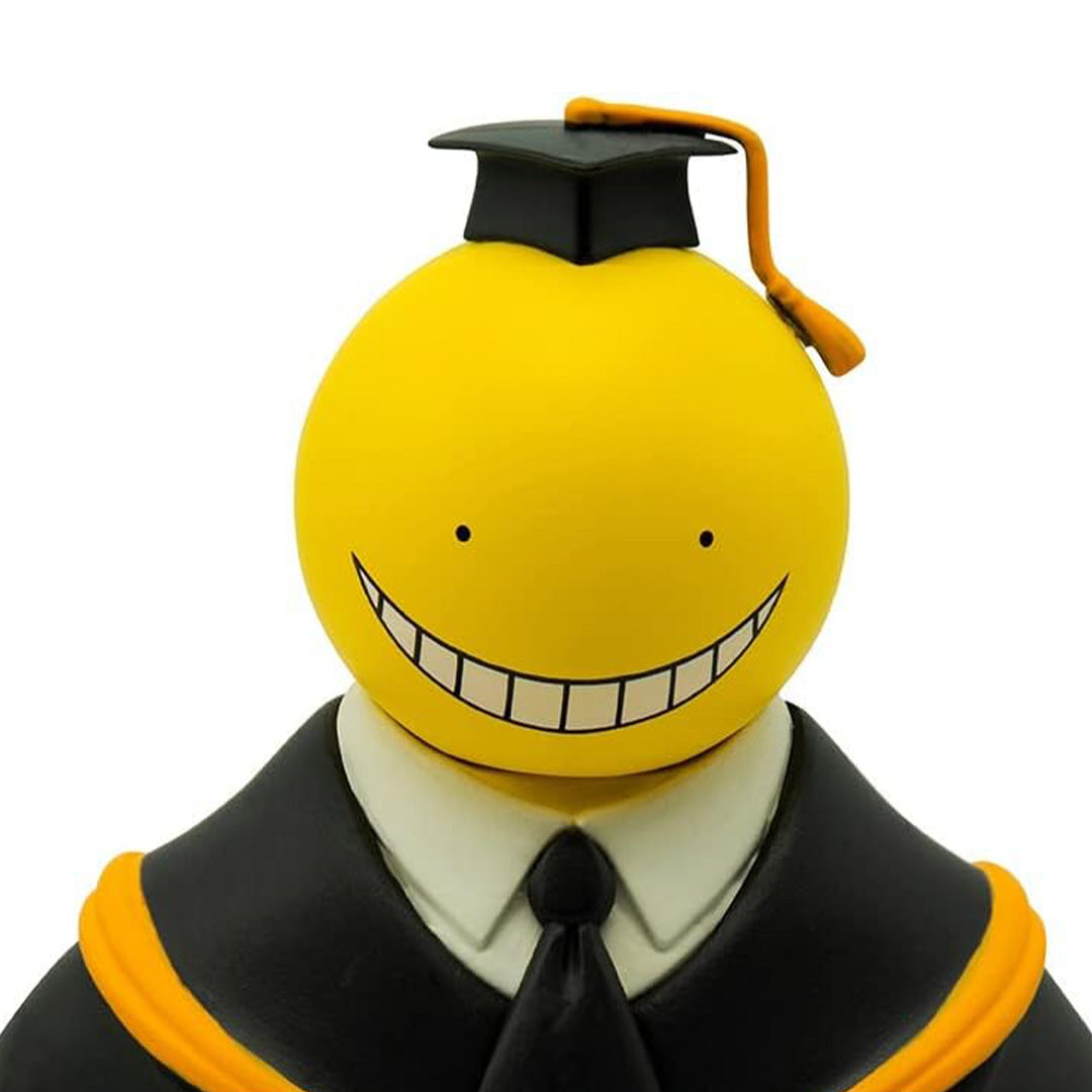 Vue 3/4 de face en plan rapproché de la figurine de Koro-sensei d'Assassination Classroom en robe de graduation, portant un chapeau.