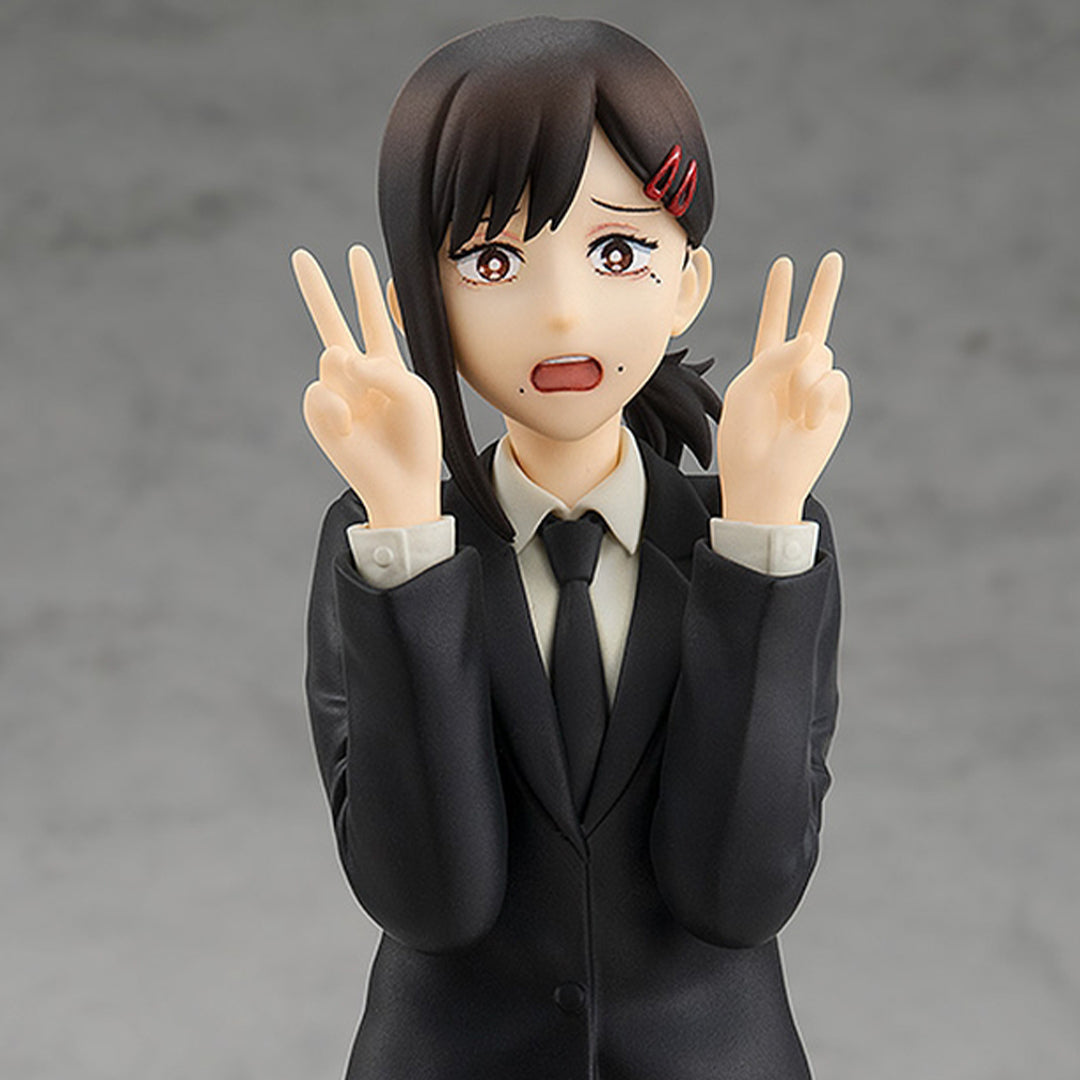Vue 3/4 de face en plan rapproché de la figurine Pop Up Parade de Kobeni Higashiyama de Chainsaw Man en costume noir, avec expression alarmée, faisant un signe de paix.