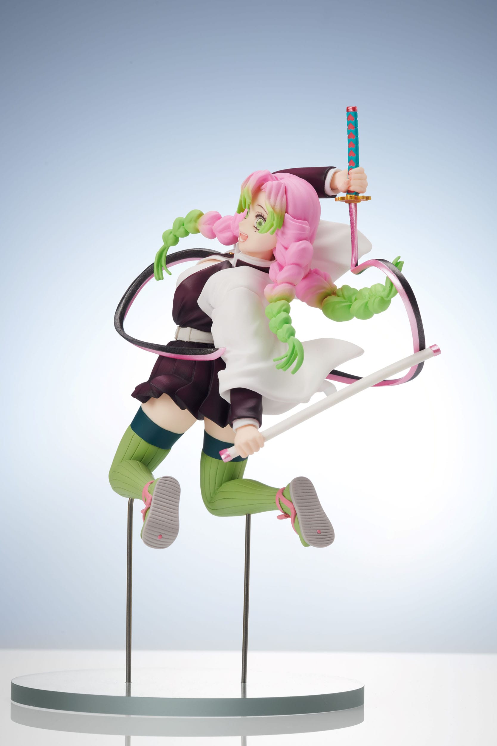 Vue 3/4 de face avec plan moyen de la figurine de Mitsuri Kanroji de Demon Slayer en uniforme de chasseur de démons, tenant un katana.