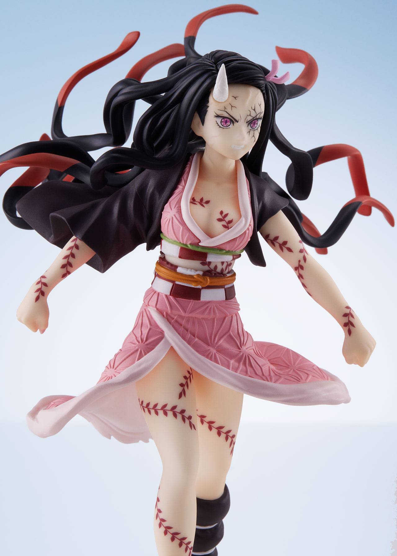 Vue 3/4 de près de la figurine de Nezuko Kamado de Demon Slayer en kimono rose, avec un museau en bambou et des marques.