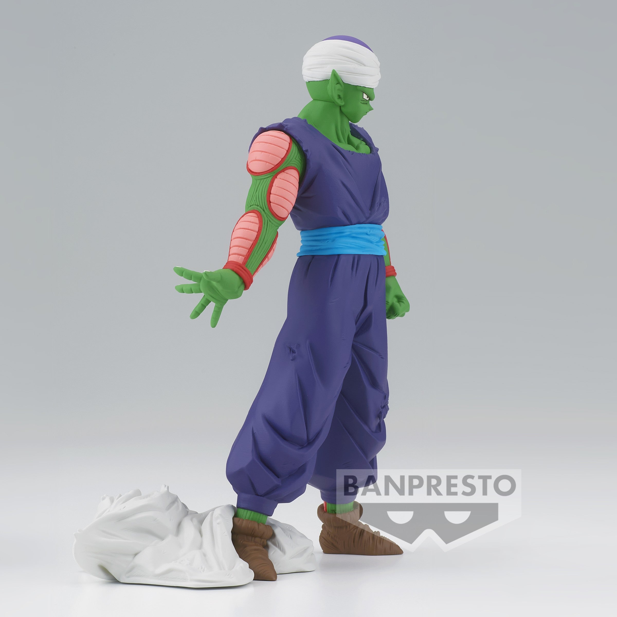 Figurine de Piccolo avec une tenue violette, tenant sa main en avant, cape au sol, exprimant la force et la détermination.