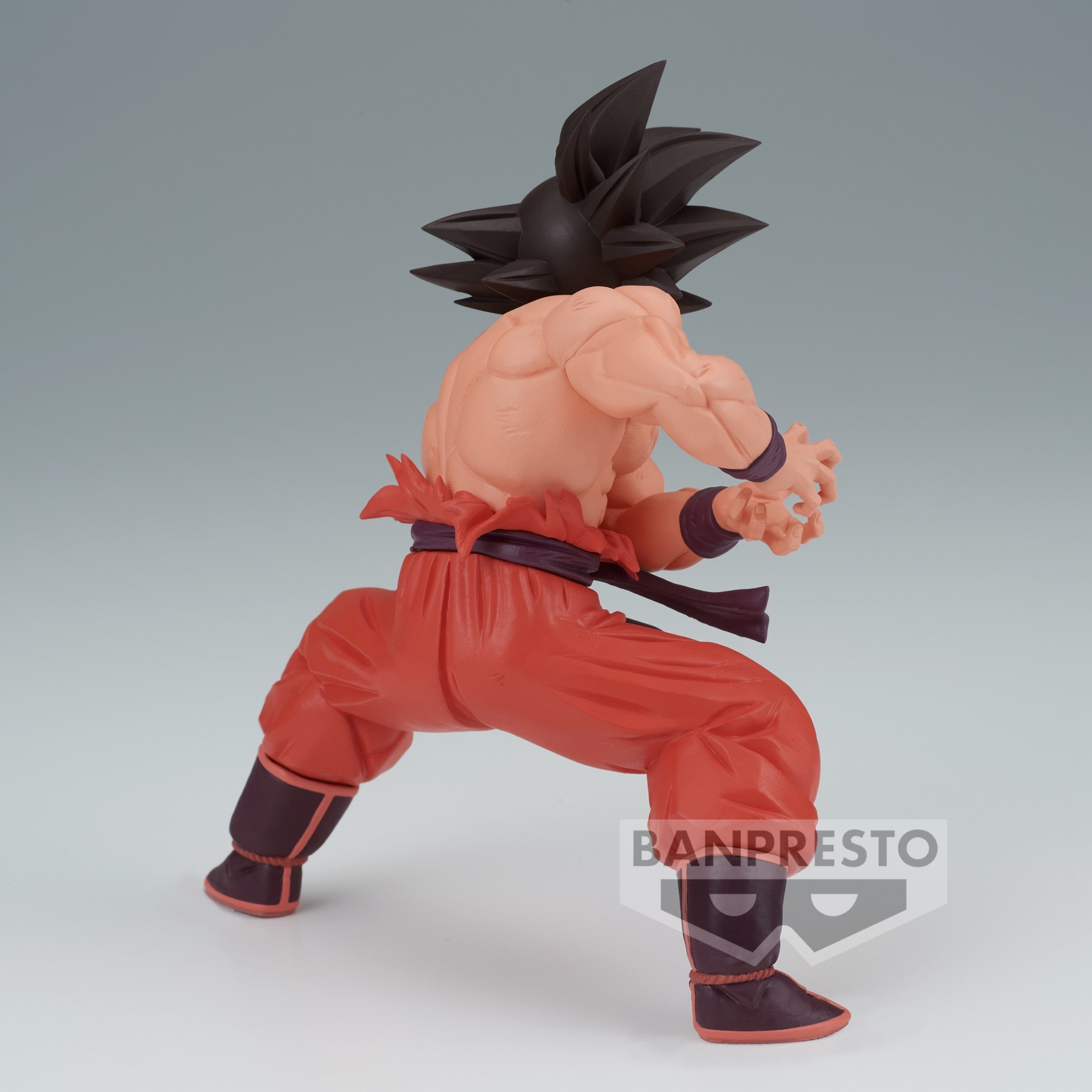 Figurine de Son Goku torse nu en train de préparer son Kamehameha, vêtue d'une tenue déchirée, représentant un moment emblématique de Dragon Ball Z.