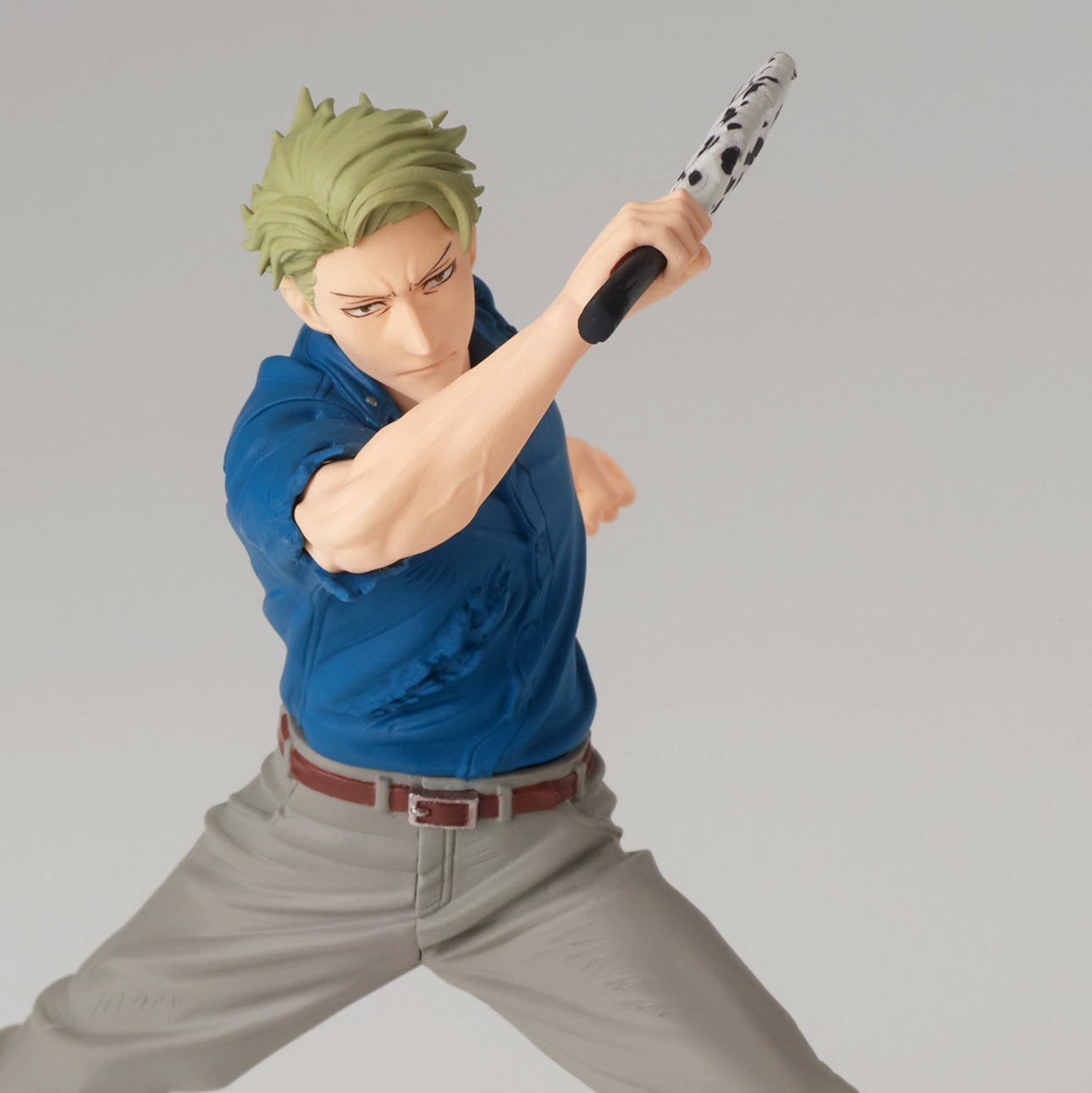 Figurine de Kento Nanami de la série Jujutsu Kaisen en chemise bleue et pantalon gris, en posture dynamique avec expression sérieuse, tenant une arme à motif noir et blanc. Vue de face à mi-distance.