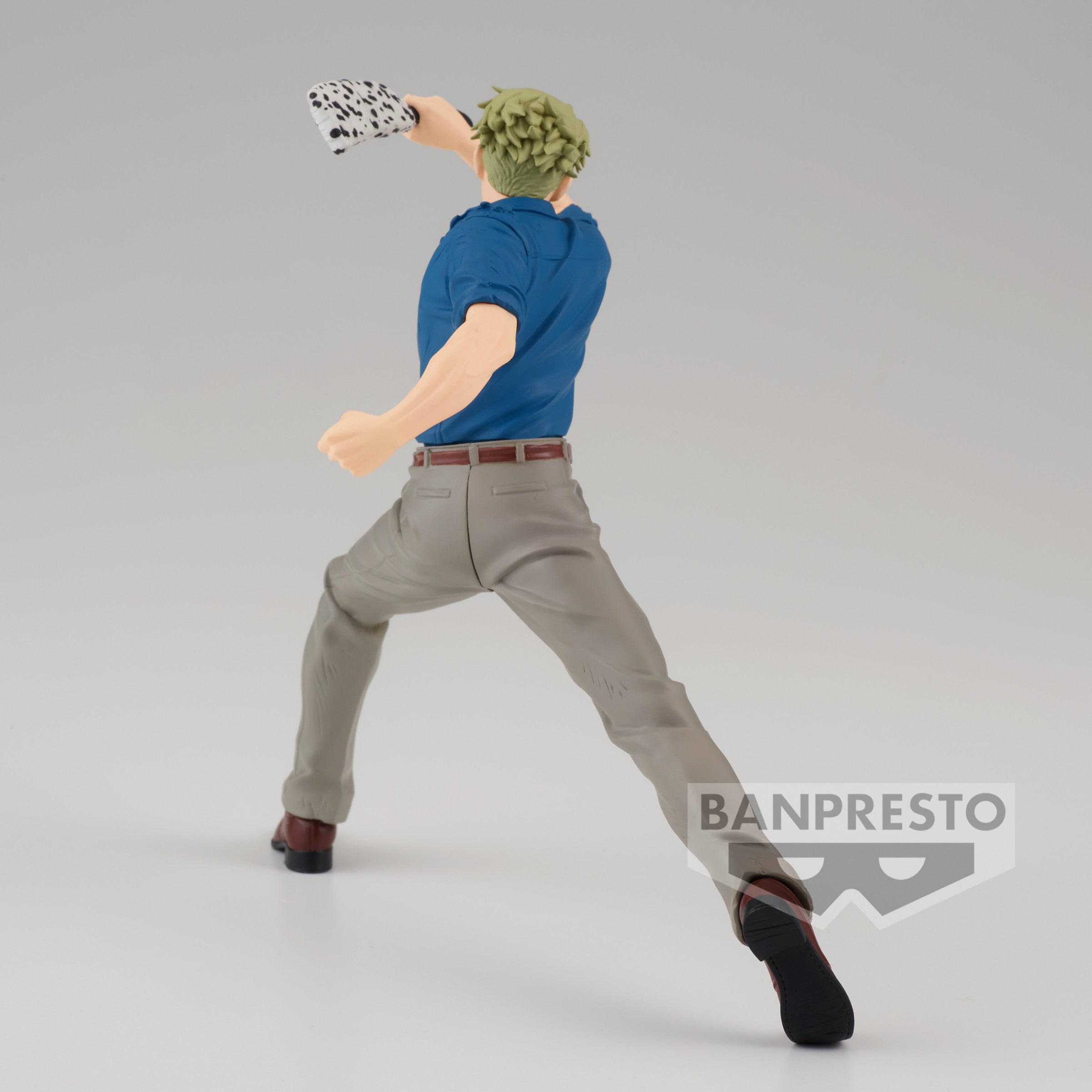Figurine Kento Nanami de la série Jujutsu Kaisen en chemise bleue et pantalon beige, en posture dynamique avec expression déterminée, tenant un objet specklé. Vue 3/4 à mi-distance.