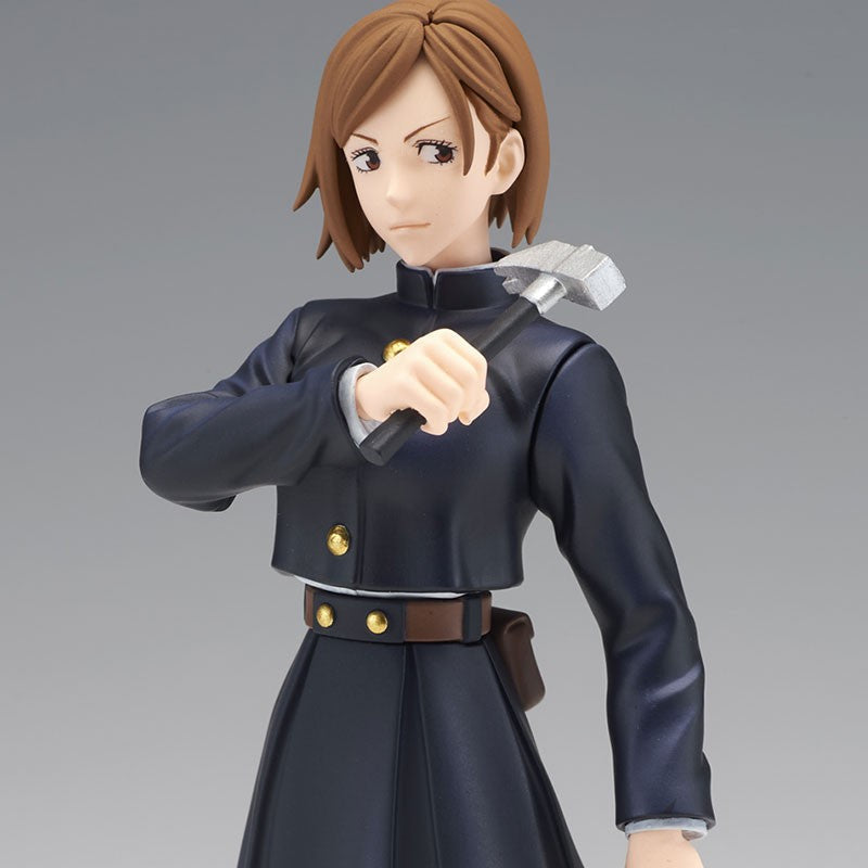 Figurine Funko Pop! de Nobara Kugisaki de la série Jujutsu Kaisen en uniforme bleu, en posture sérieuse avec expression déterminée, tenant un petit marteau argenté. Vue de face à mi-distance.