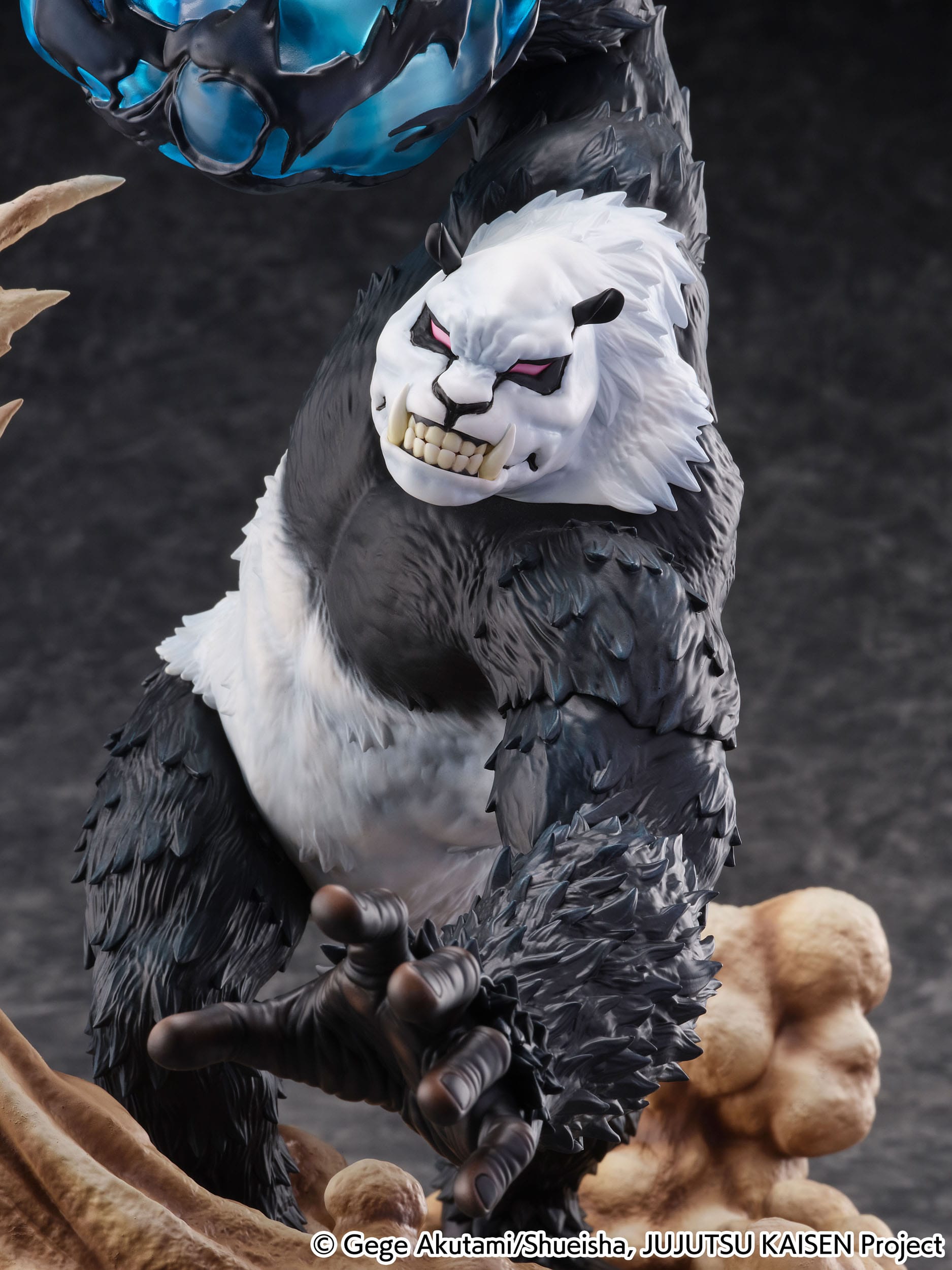 Figurine de Panda de la série Jujutsu Kaisen en pelage noir et blanc, en posture agressive avec expression intense, tenant un orbe d'énergie. Vue de face à mi-distance.