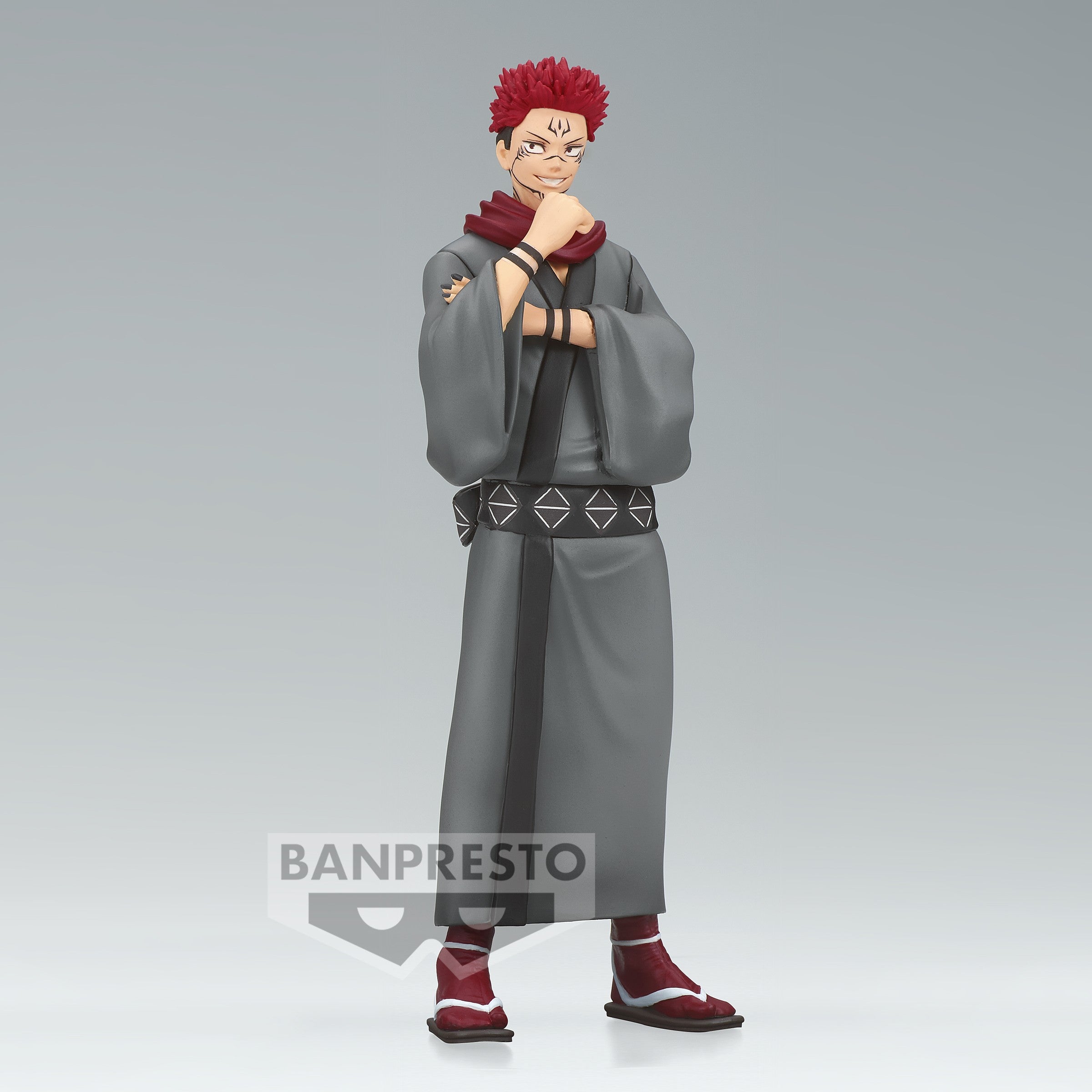 Figurine de Ryomen Sukuna de la série Jujutsu Kaisen en kimono gris, en posture confiante avec un sourire, main sous le menton. Vue de face à mi-distance.