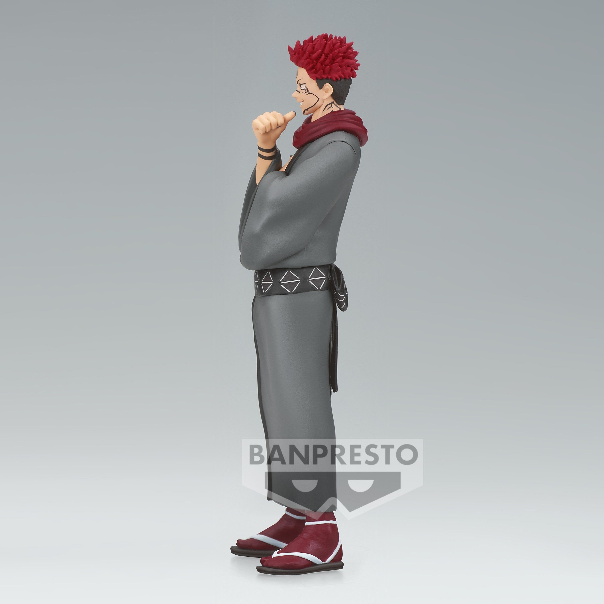 Figurine Funko Pop! de Ryomen Sukuna de la série Jujutsu Kaisen en tenue grise avec écharpe rouge, en posture debout avec expression confiante, main près du menton. Vue de côté à mi-distance.