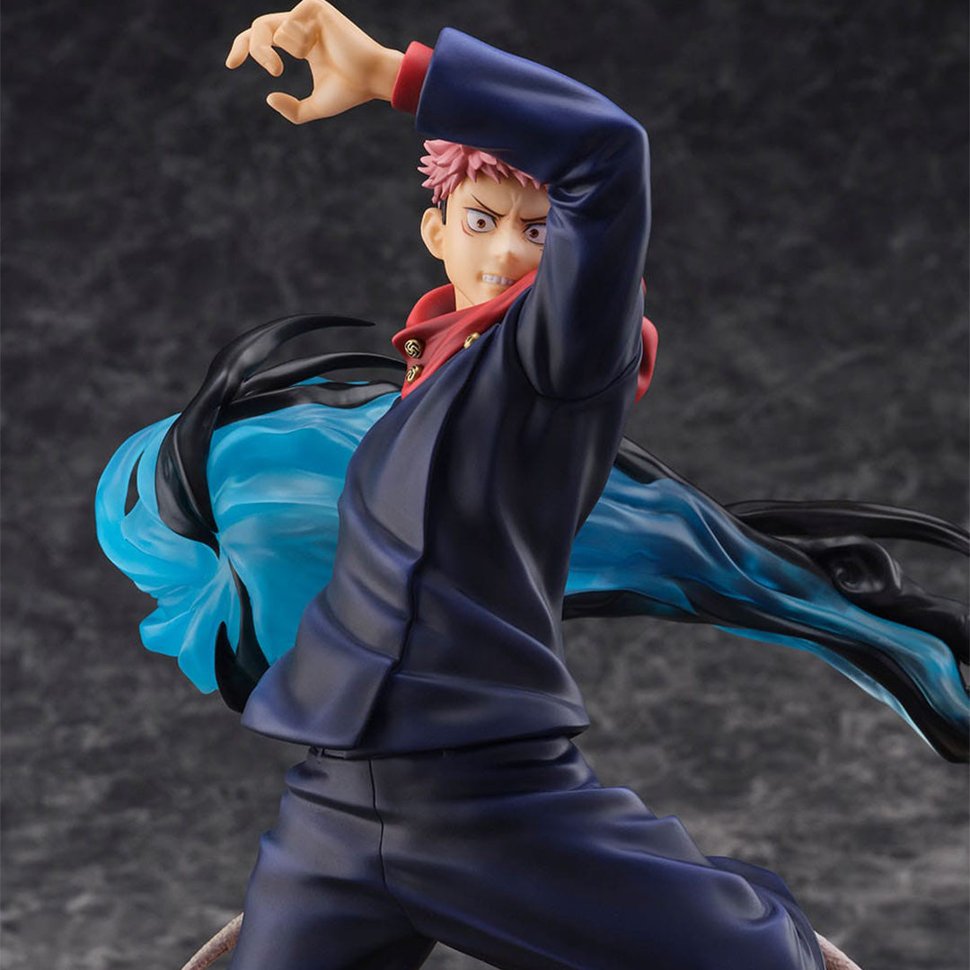 Figurine de Yuji Itadori de la série Jujutsu Kaisen en tenue bleue, en posture dynamique avec expression déterminée, entouré d'énergie tourbillonnante. Vue de face à mi-distance.