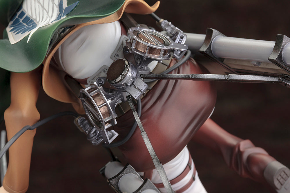 Vue 3/4 dynamique à mi-distance de la figurine ARTFX J de Mikasa Ackerman de Shingeki no Kyojin en tenue militaire, avec cape et équipement.