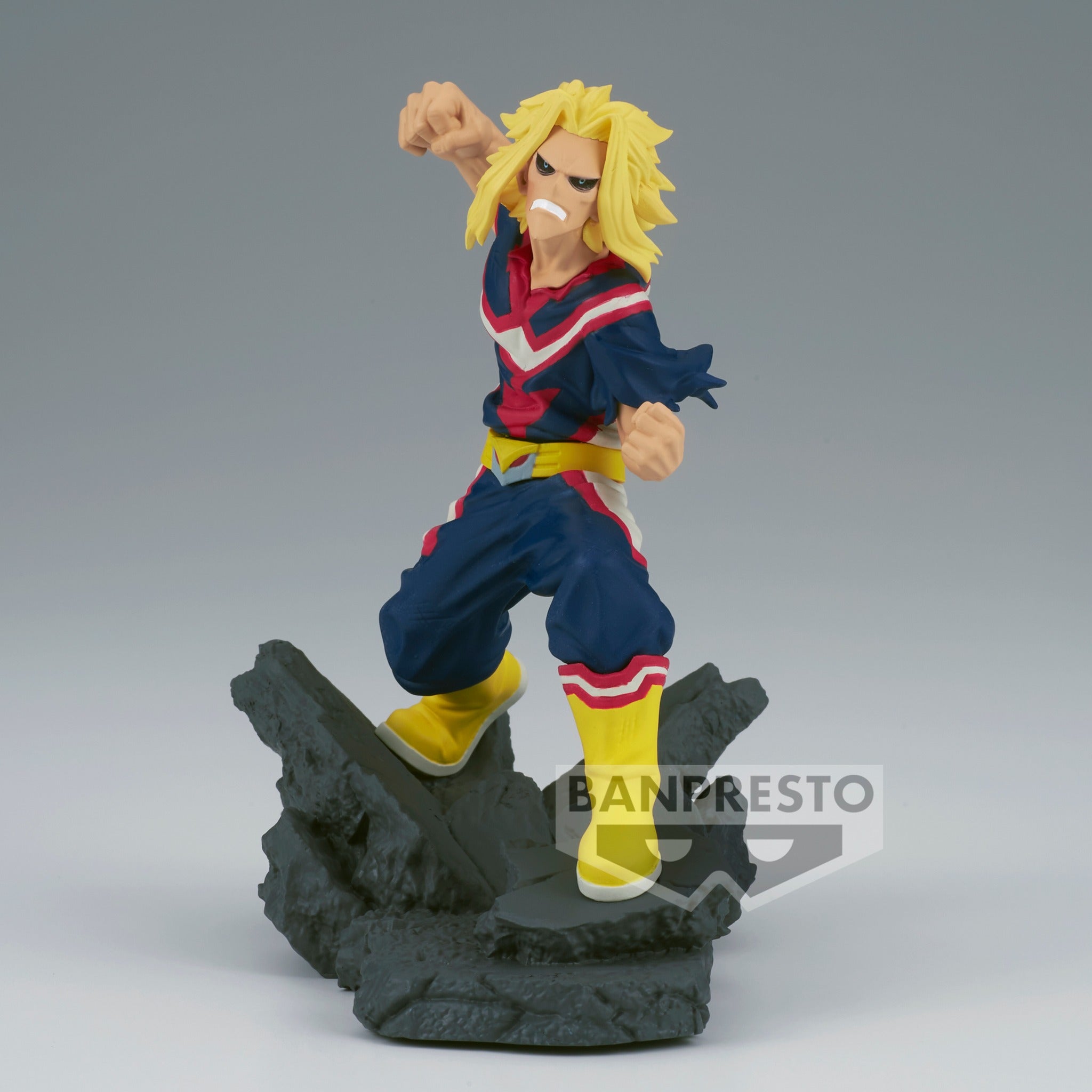 Vue 3/4 de face à mi-distance de la figurine de All Might de My Hero Academia en costume de super-héros, sur une base en débris.