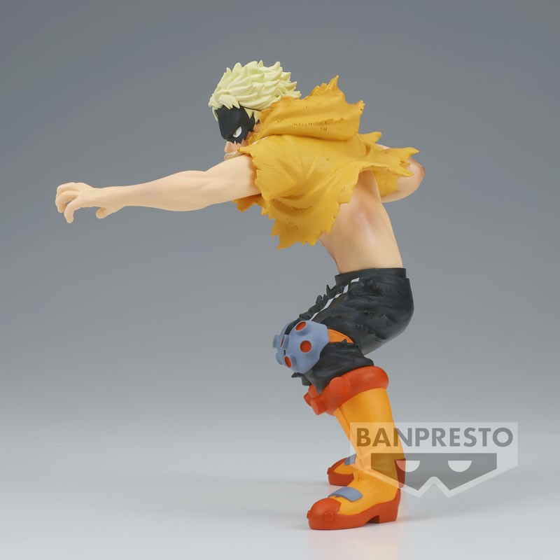 Vue de profil à mi-distance de la figurine de Fat Gum de My Hero Academia en cape jaune, avec un masque noir.