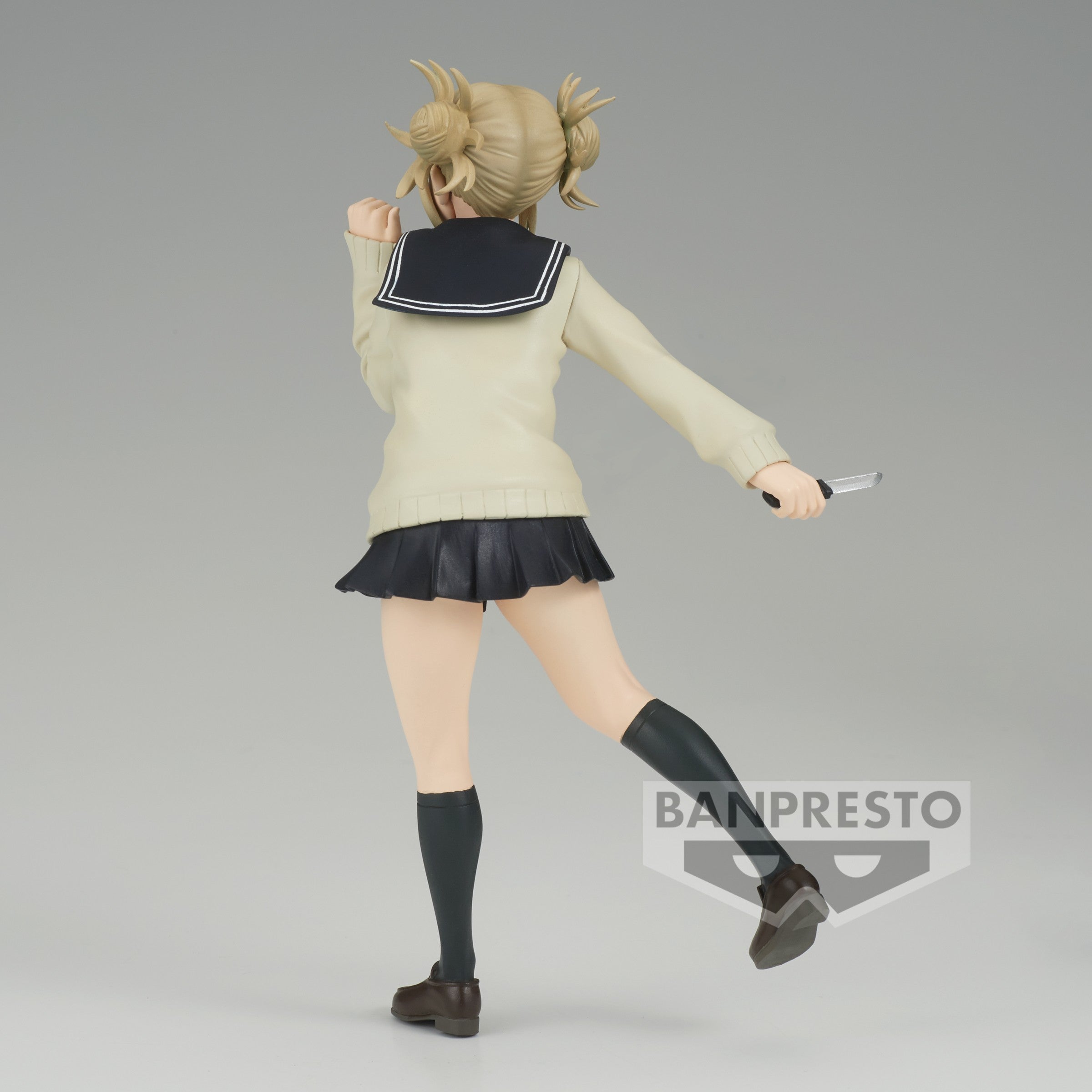 Vue 3/4 arrière à mi-distance de la figurine de Himiko Toga de My Hero Academia en pull crème et jupe noire, tenant un couteau dans la main droite.