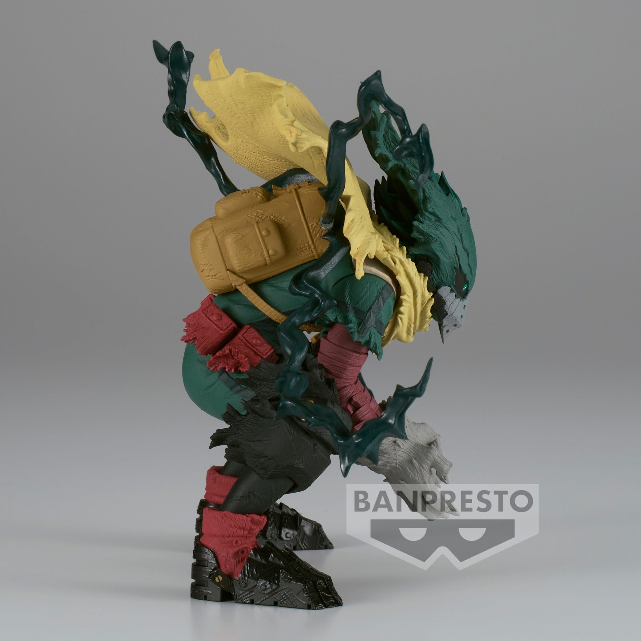 Vue de profil à mi-distance de la figurine  d'Izuku Midoriya de My Hero Academia en position accroupie, portant une cape jaune déchirée.