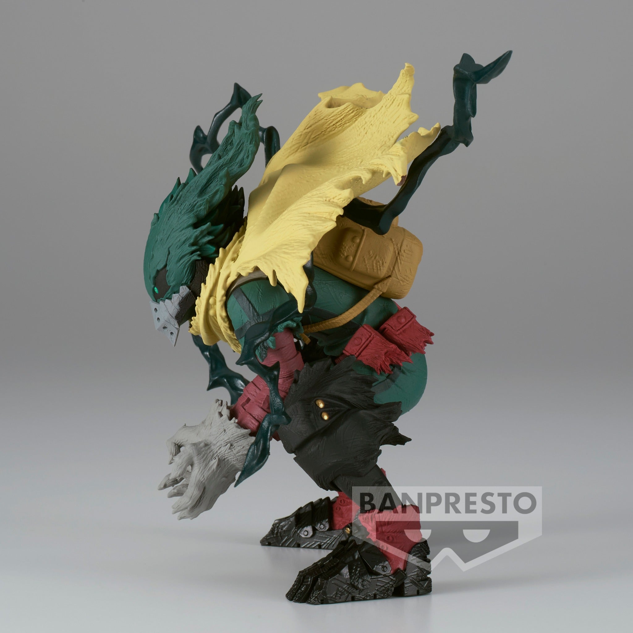 Vue de profil à mi-distance de la figurine de Izuku Midoriya de My Hero Academia en costume de héros, avec un manteau déchiré et un sac à dos.
