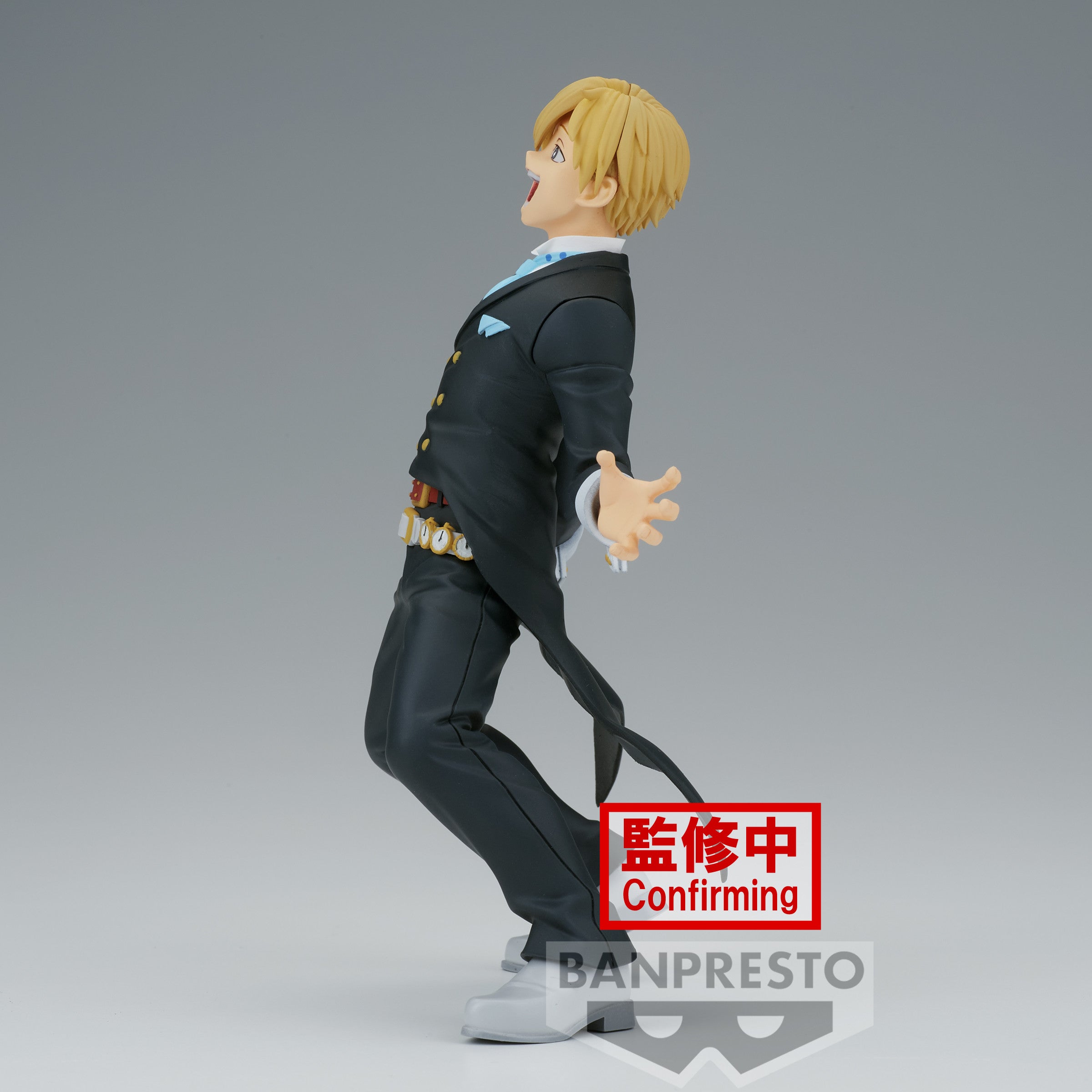 Vue 3/4 de face à mi-distance de la figurine d'un personnage inconnu, en tenue noire avec chemise blanche et accents bleus, en posture dynamique.