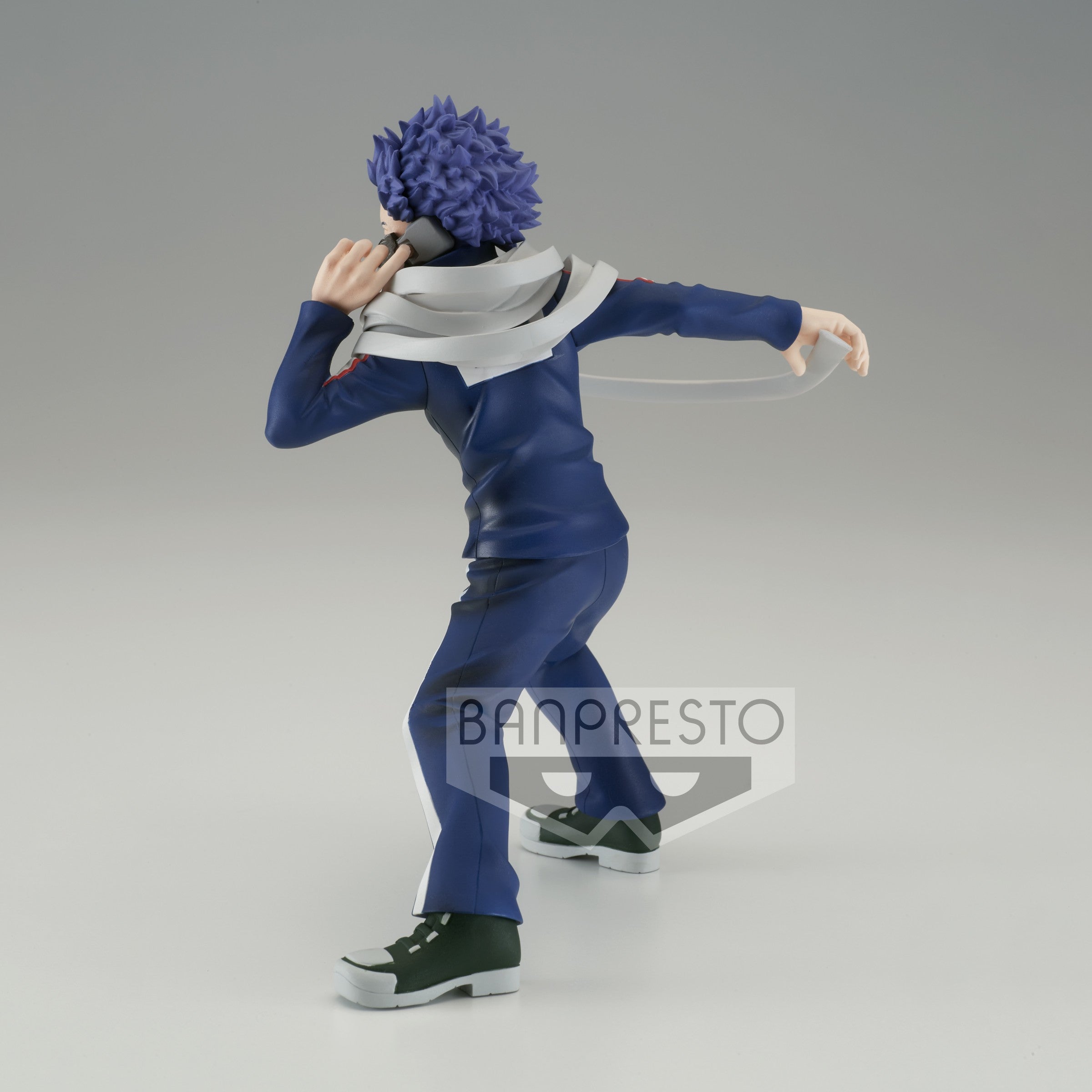 Vue 3/4 arrière à mi-distance de la figurine d'Hitoshi Shinso de My Hero Academia en uniforme bleu, tenant un téléphone.