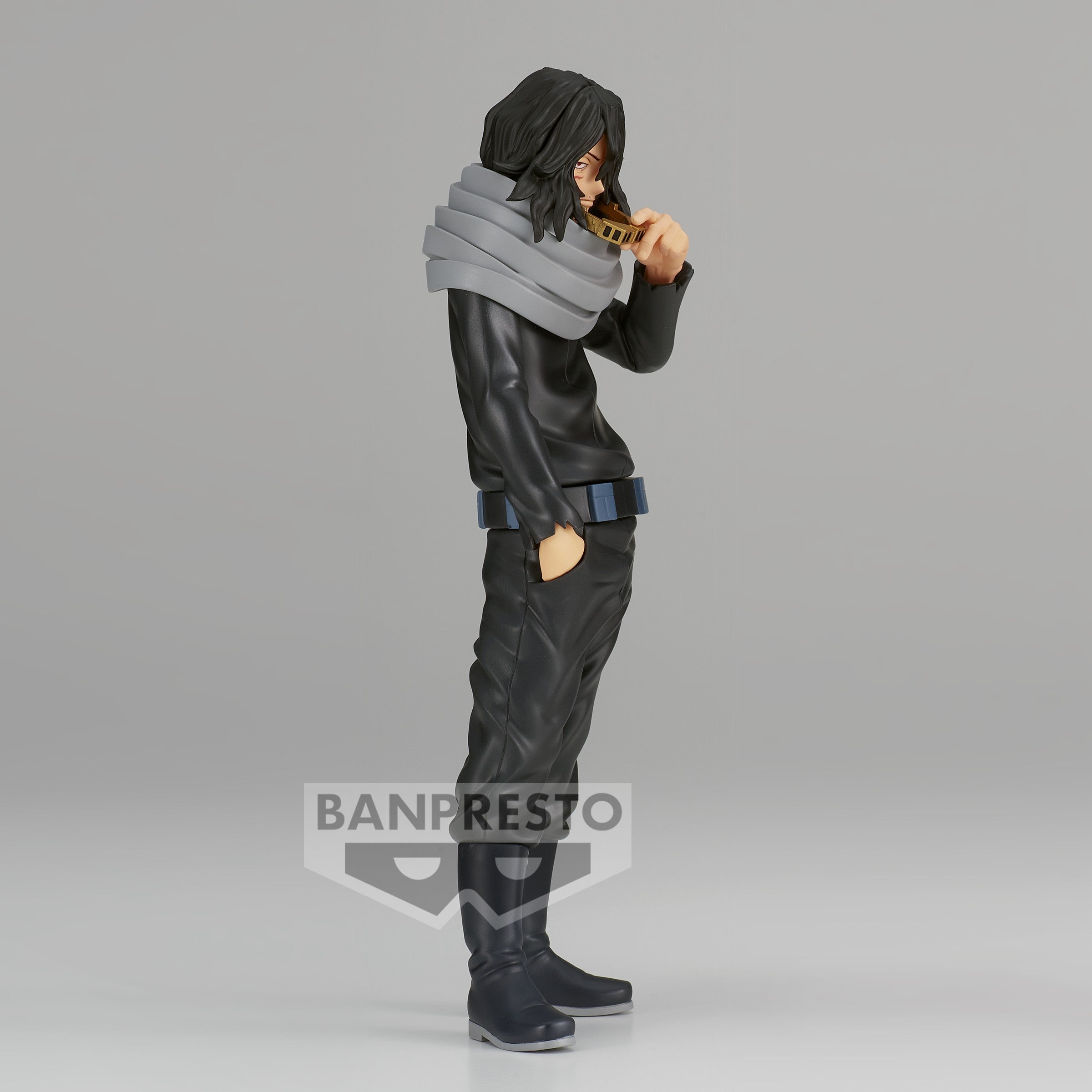 Vue 3/4 de face à mi-distance de la figurine de Shota Aizawa de My Hero Academia en costume noir avec écharpe grise, tenant une collation.