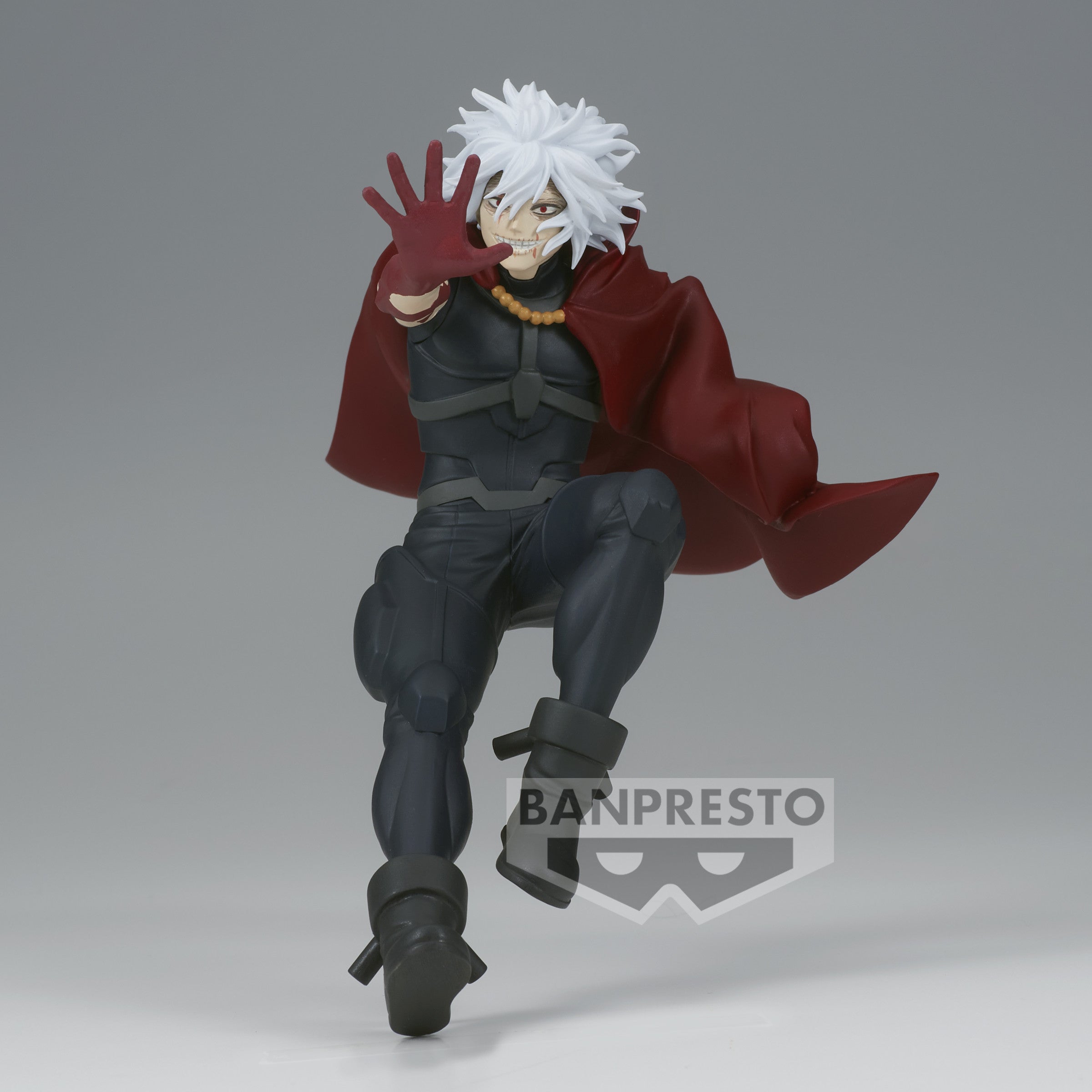Vue 3/4 de face à mi-distance de la figurine de Tomura Shigaraki de My Hero Academia en tenue sombre avec une cape rouge, main squelettique tendue.
