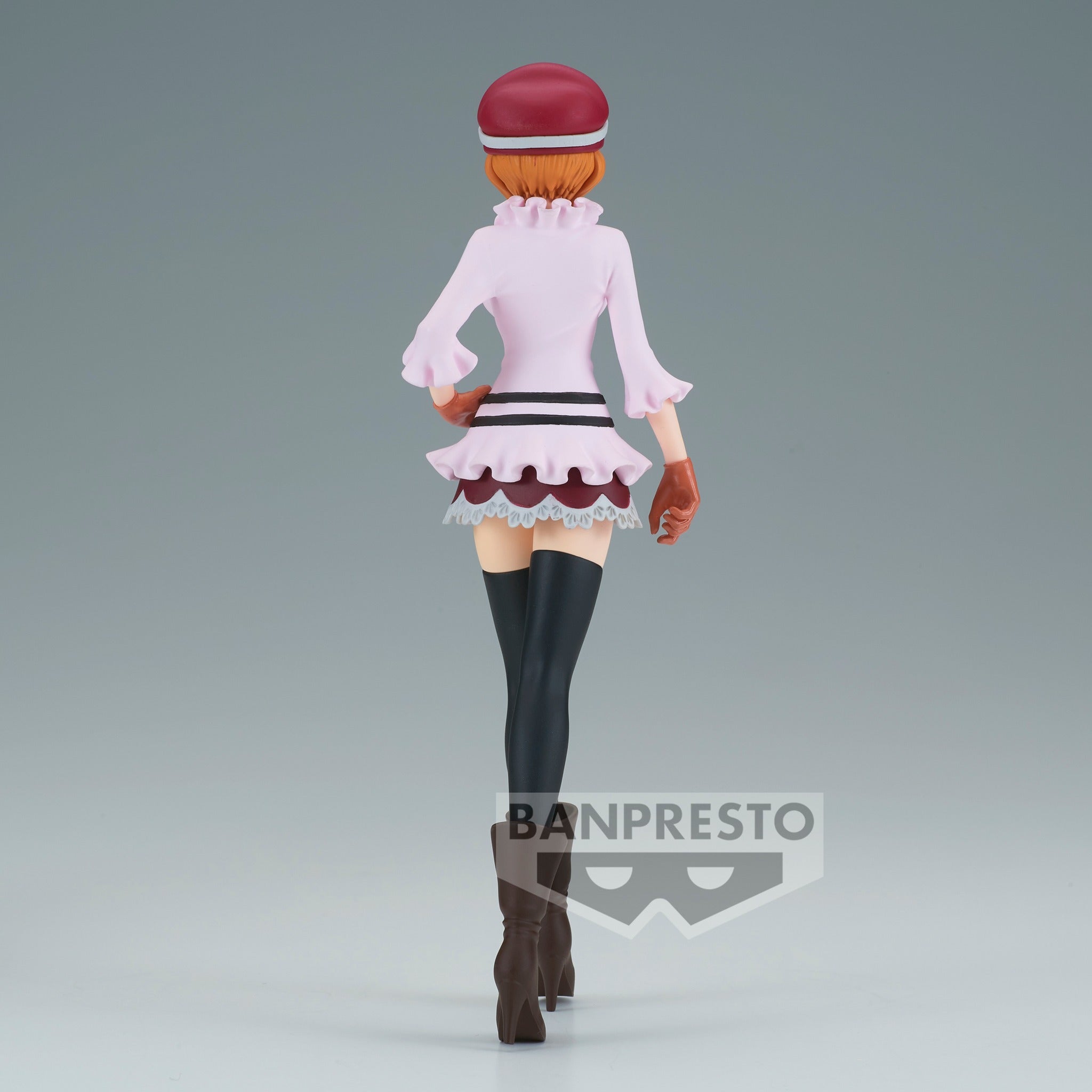 Figurine de Koala en posture dynamique avec un sourire malicieux, portant une casquette fuchsia, des lunettes jaunes surdimensionnées, un haut rose pâle, et une jupe à volants rose foncé, accompagnée de chaussettes noires montantes et de bottines à talons marron.