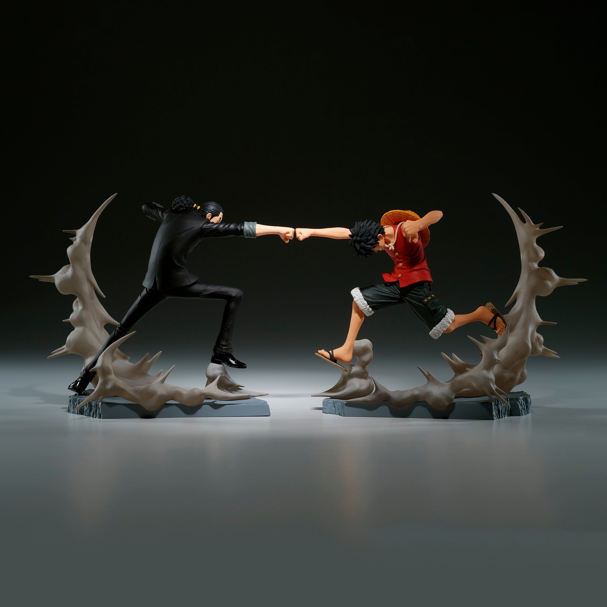 Figurine de Luffy et Rob Lucci en pleine action, leurs poings s'entrechoquant, avec des effets de fumée émanant du socle, fabriquée en PVC par Banpresto.