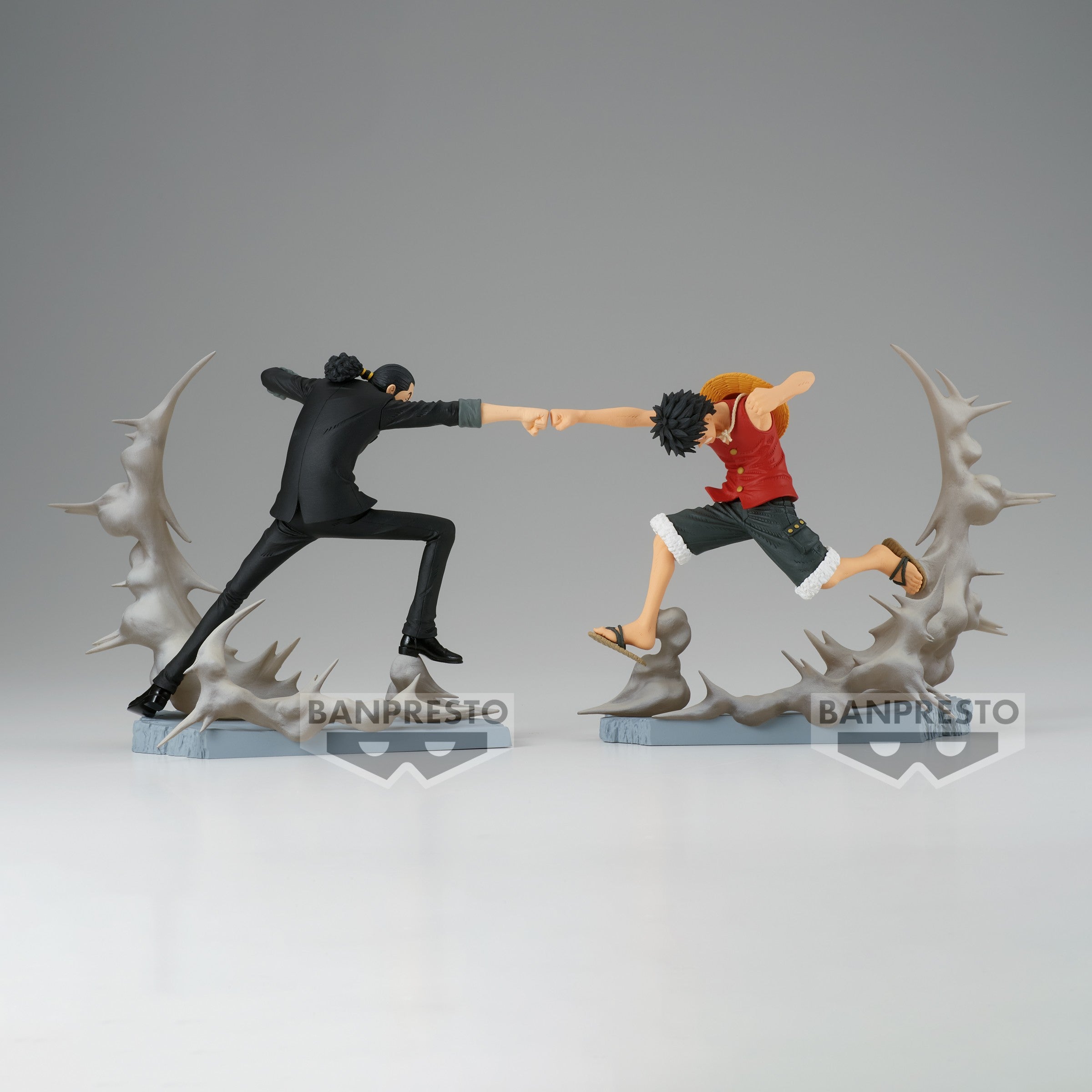 Figurine de Luffy et Rob Lucci en pleine action, leurs poings s'entrechoquant, avec des effets de fumée émanant du socle, fabriquée en PVC par Banpresto.