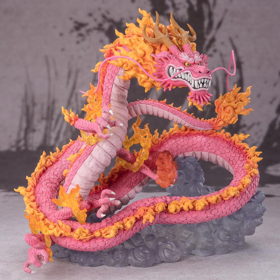Figurine de Momonosuke Kozuki en PVC, représentant le personnage en pose dynamique, avec des écailles roses et des nuages dorés entourant ses pattes. Dimensions de 28,5 cm, fabriquée par TAMASHII NATIONS.