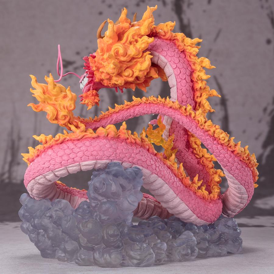 Figurine de Momonosuke Kozuki en PVC, représentant le personnage en pose dynamique, avec des écailles roses et des nuages dorés entourant ses pattes. Dimensions de 28,5 cm, fabriquée par TAMASHII NATIONS.