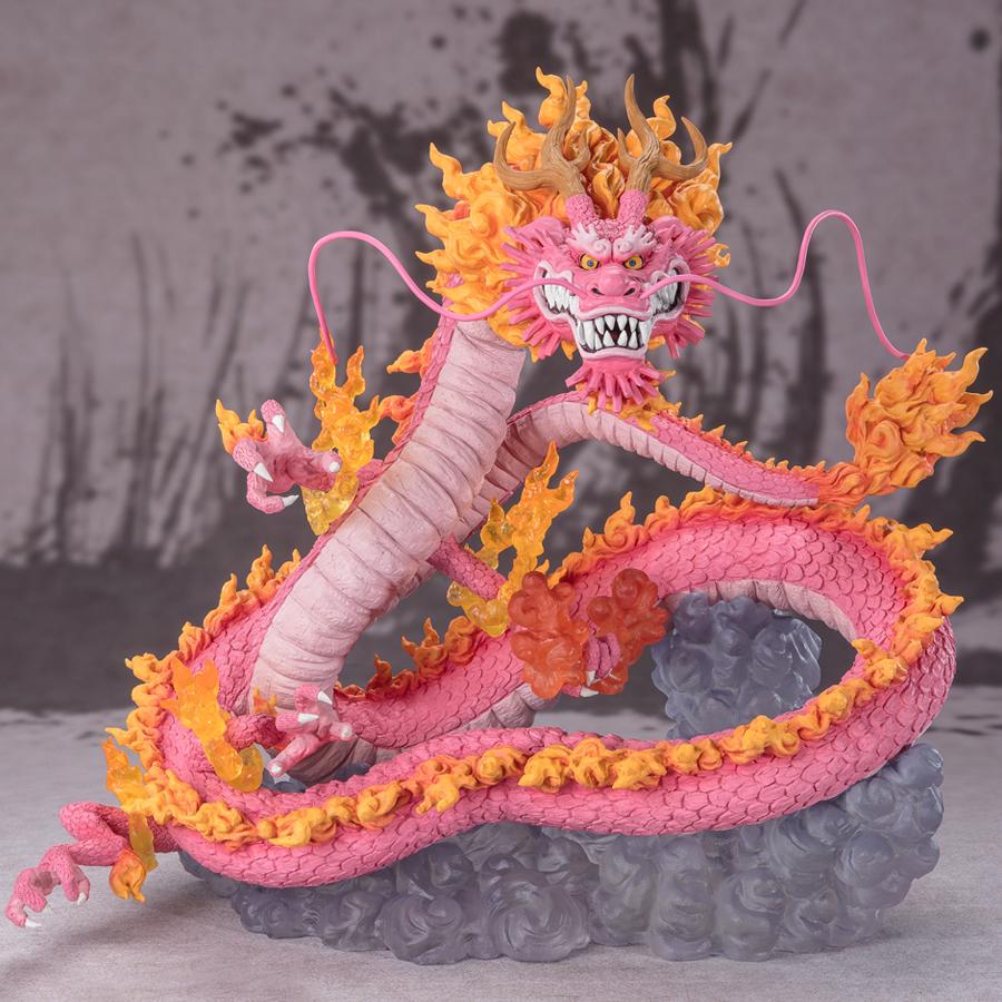 Figurine de Momonosuke Kozuki en PVC, représentant le personnage en pose dynamique, avec des écailles roses et des nuages dorés entourant ses pattes. Dimensions de 28,5 cm, fabriquée par TAMASHII NATIONS.