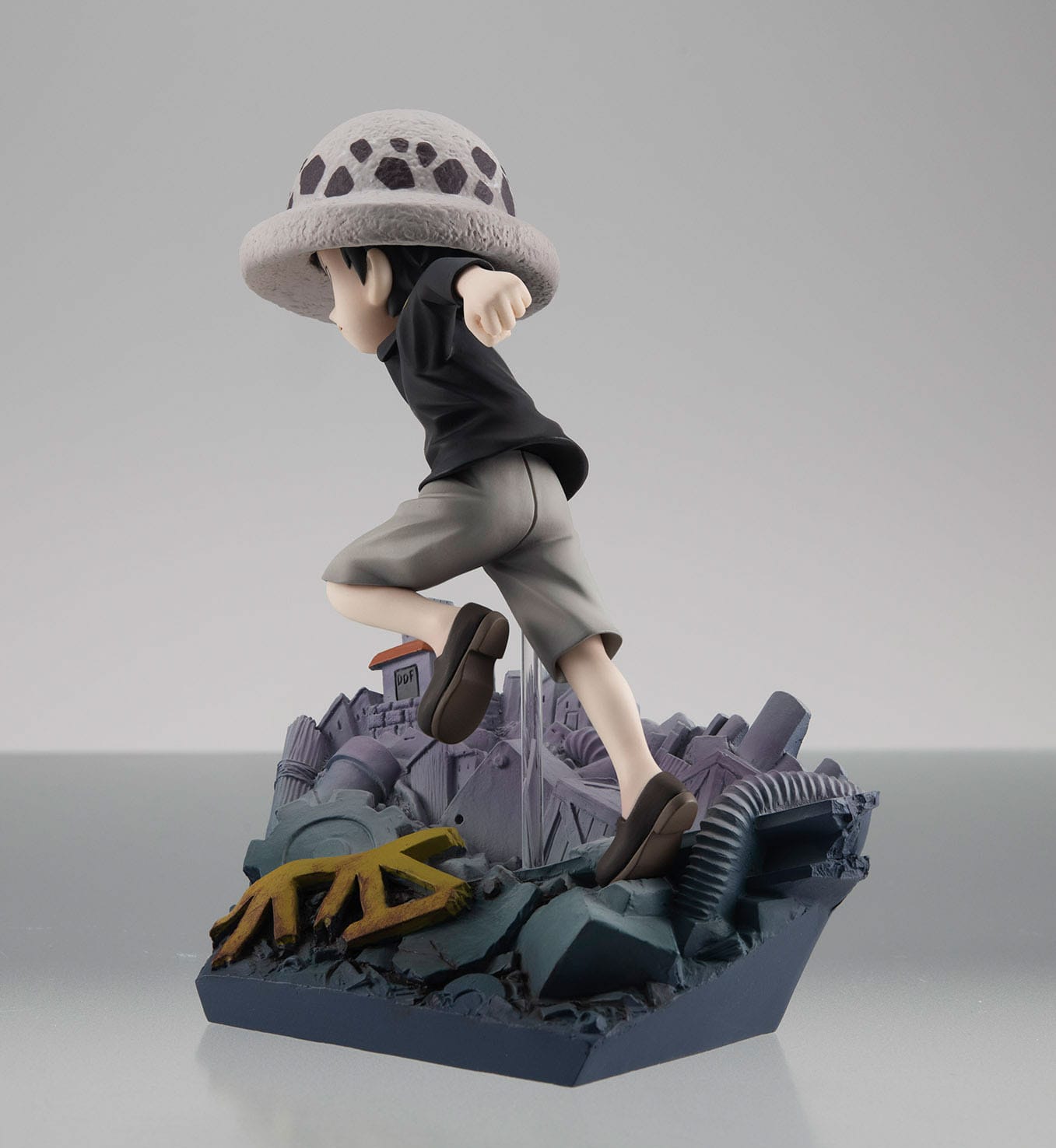 Figurine de Trafalgar Law courant avec détermination sur un diorama représentant la Ville Blanche, fabriquée en PVC par MegaHouse, mesurant 13 cm avec des détails précis et une finition soignée.