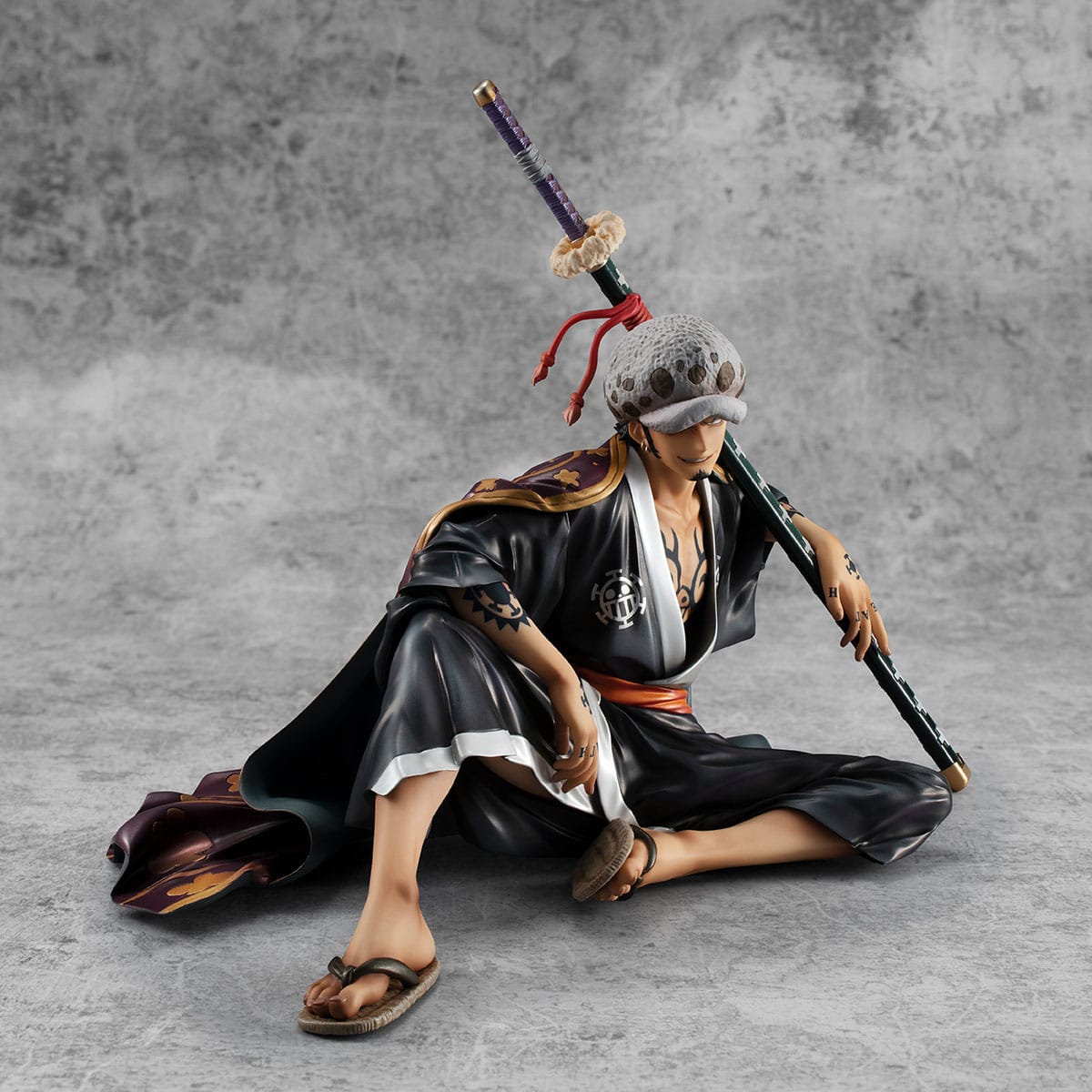 Figurine de Trafalgar Law, capitaine des Heart Pirates, tenant son gigantesque sabre avec des effets de lumière bleutée, fabriquée par MEGAHOUSE.