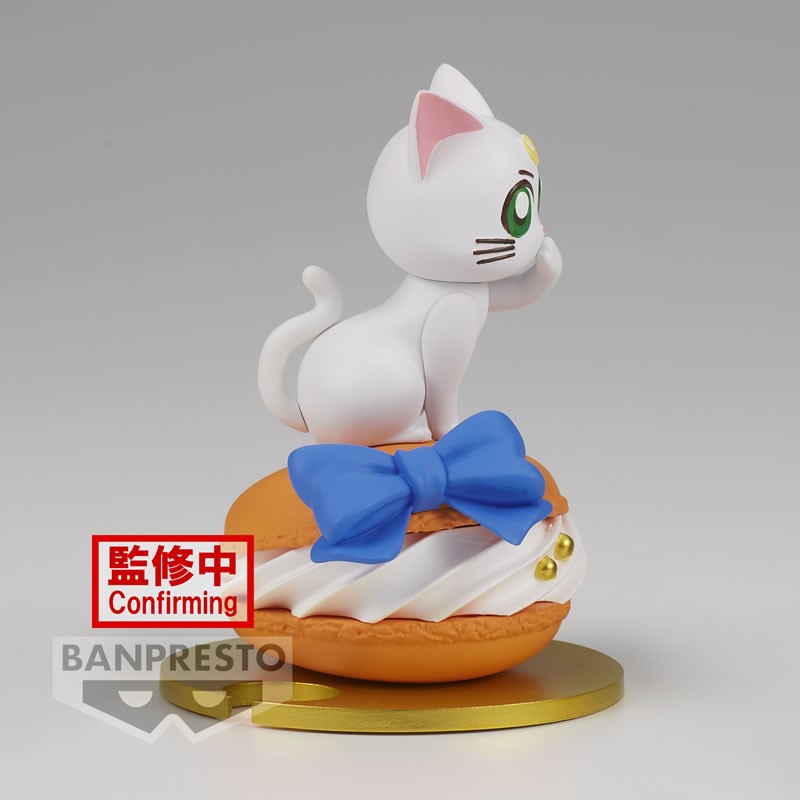 Vue 3/4 en plan d'ensemble de la figurine Paldolce Collection d'Artemis de Sailor Moon assis sur une pâtisserie.