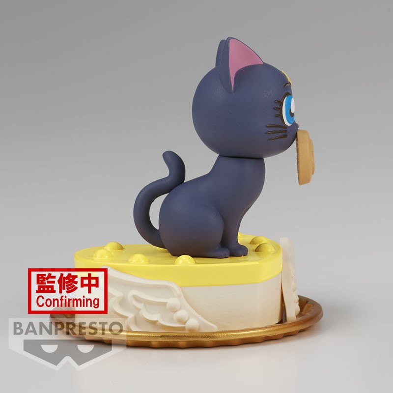 Vue de profil en plan d'ensemble de la figurine de Luna de Sailor Moon tenant un objet doré dans sa gueule.