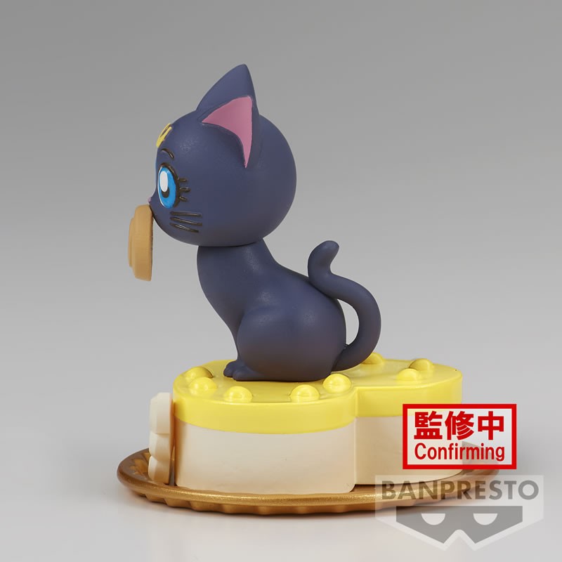 Vue latérale en plan d'ensemble de la figurine de Luna de Sailor Moon tenant un biscuit dans sa bouche.