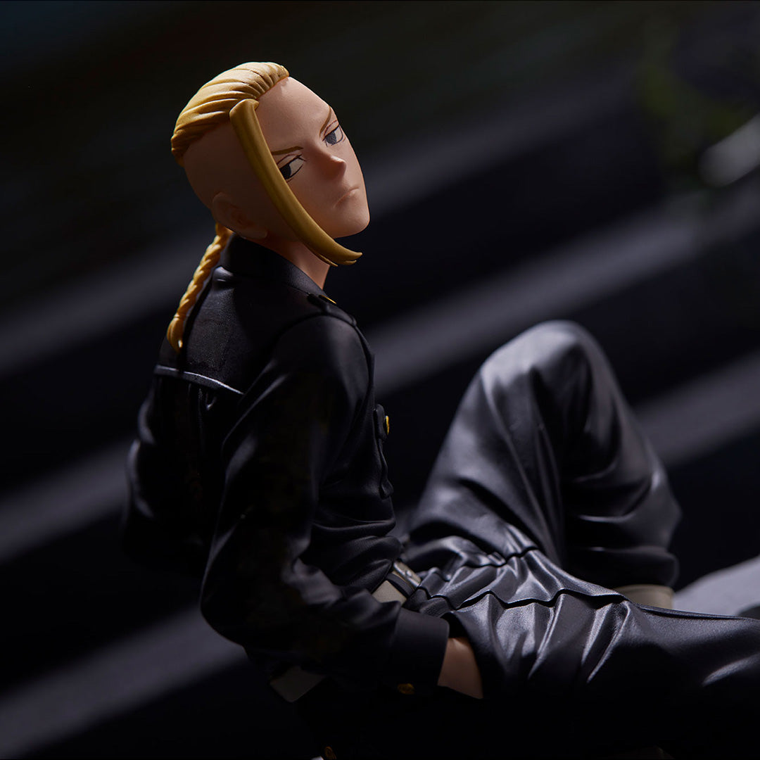 Vue 3/4 arrière à mi-distance de la figurine de Ken Ryuguji de Tokyo Revengers en veste militaire noire, cheveux blonds tressés.