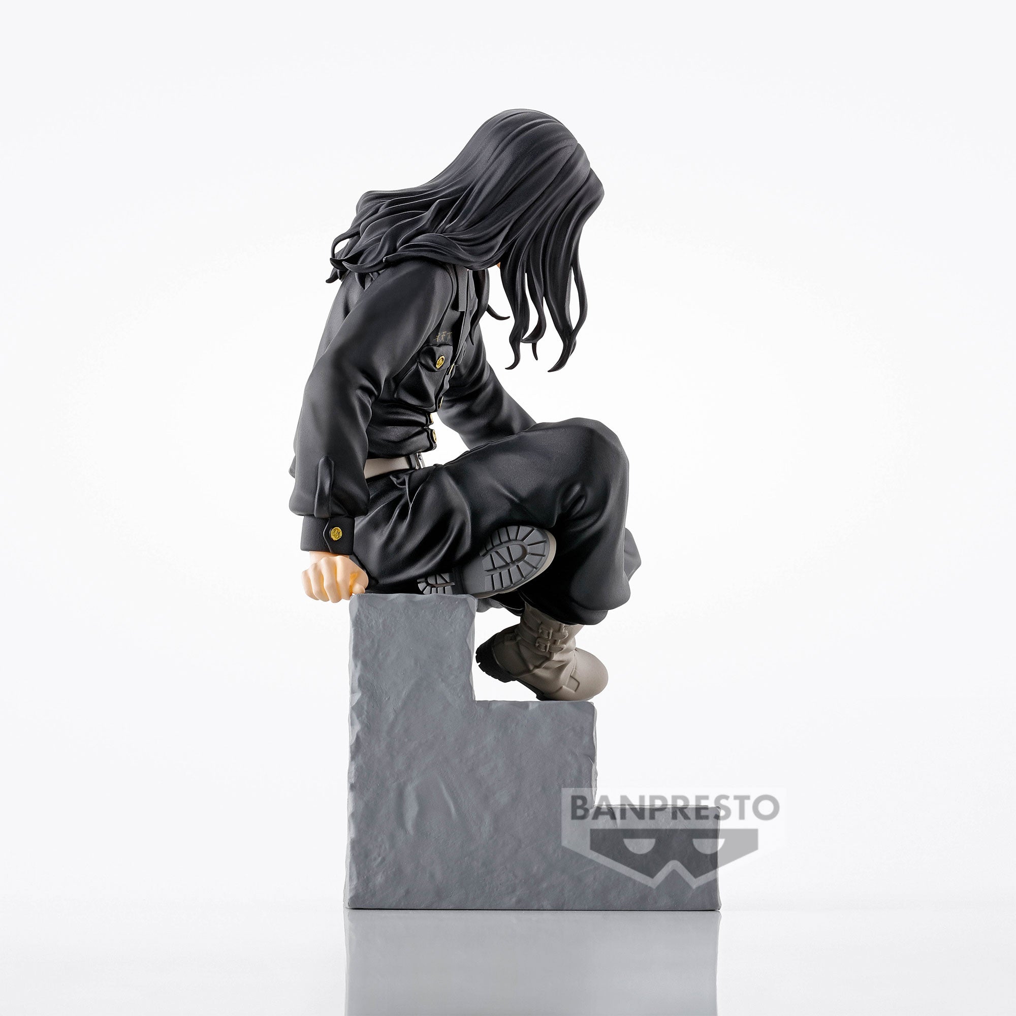 Vue de profil à mi-distance de la figurine de Keisuke Baji de Tokyo Revengers en tenue noire tactique, sur une base texture pierre.