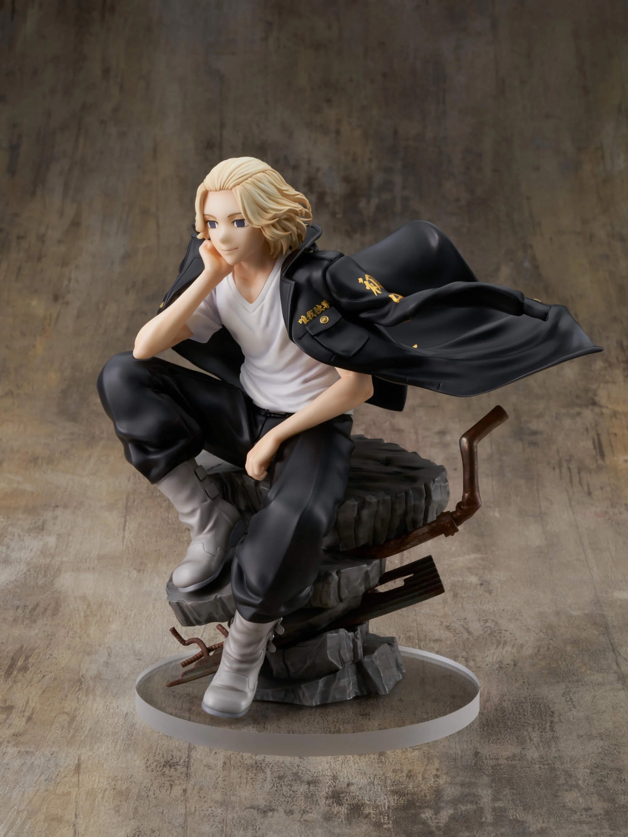 Vue 3/4 de face en plan rapproché moyen de la figurine de Manjiro Sano de Tokyo Revengers en chemise blanche et veste noire, assis sur une base rocheuse.