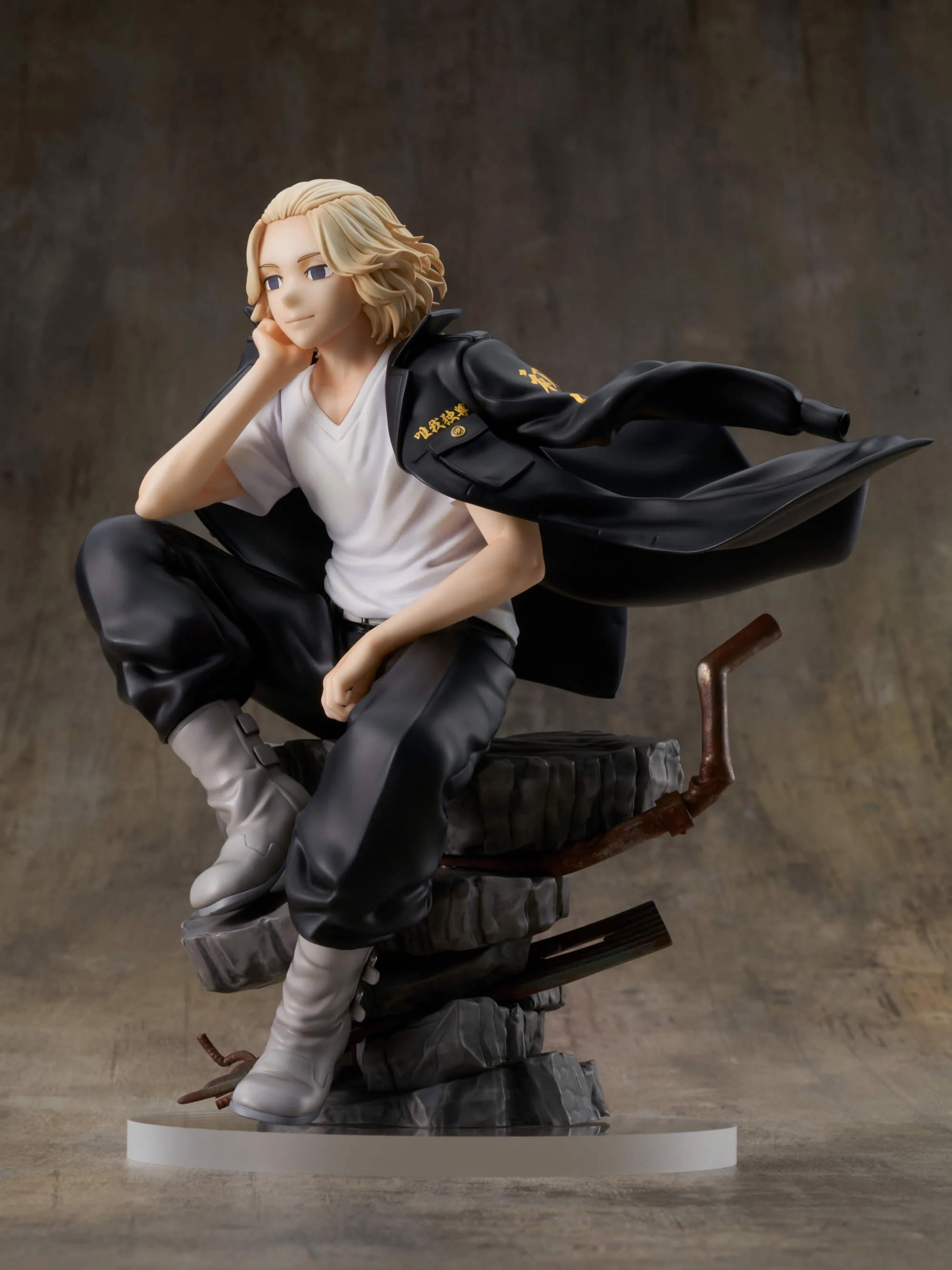 Vue 3/4 de face en plan rapproché moyen de la figurine de Manjiro "Mikey" Sano de Tokyo Revengers en T-shirt blanc et veste noire, avec une base stylisée en pierres empilées.