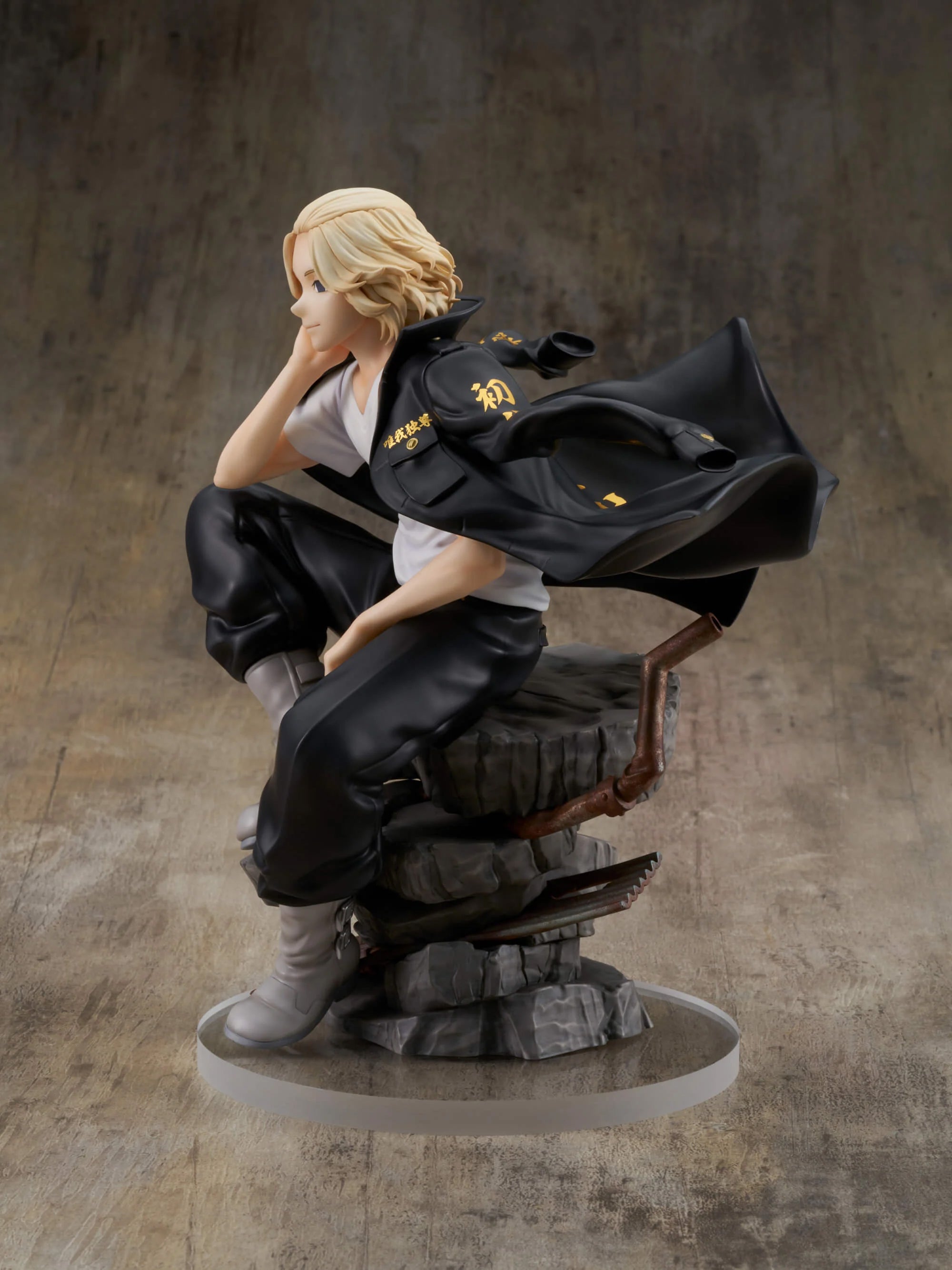Vue 3/4 de face en plan rapproché moyen de la figurine de Manjiro Sano (Mikey) de Tokyo Revengers en t-shirt blanc et veste noire, sur une base rocheuse.