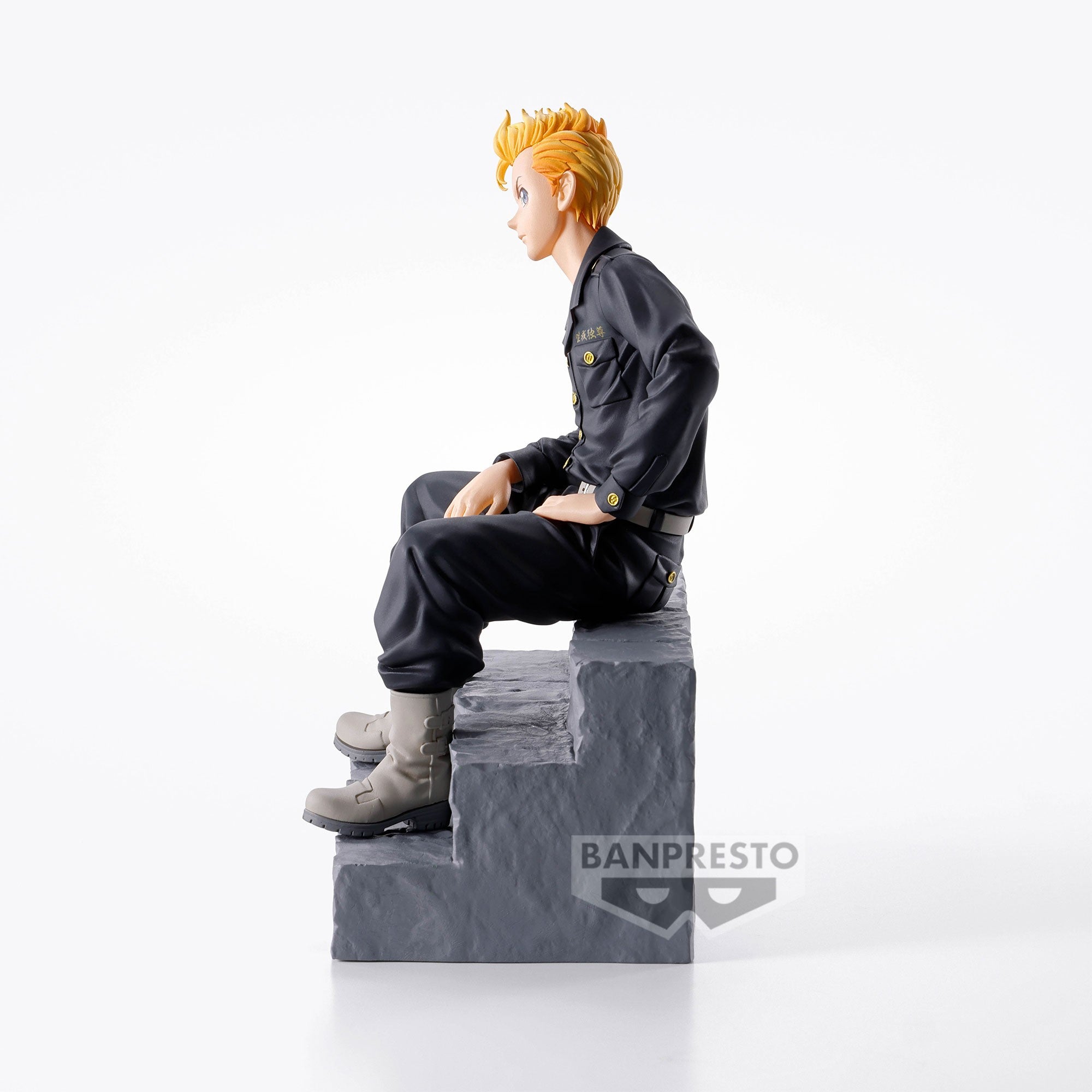 Vue 3/4 de face à mi-distance de la figurine de Takemichi Hanagaki de Tokyo Revengers en uniforme noir, assis sur une marche.