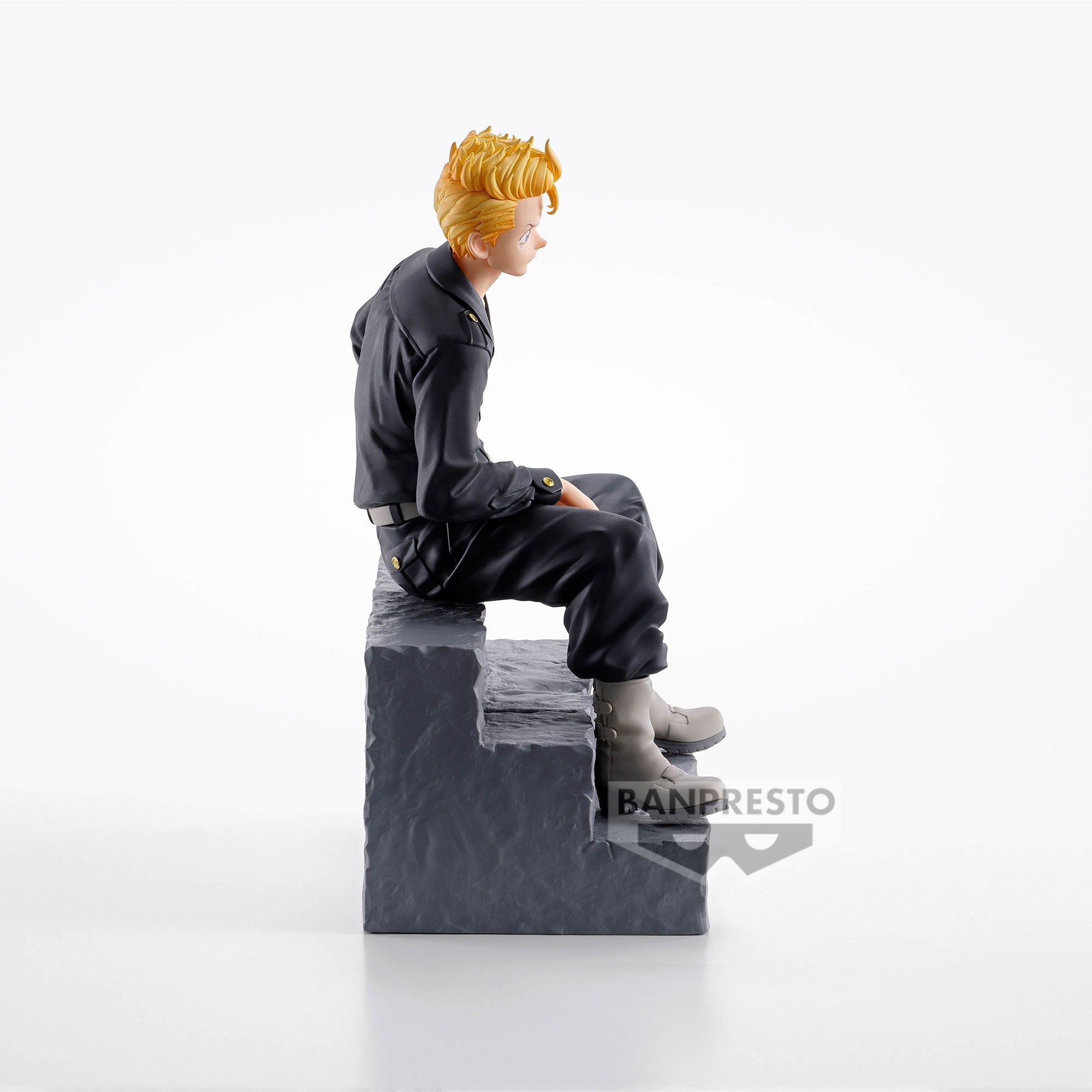 Vue 3/4 arrière à mi-distance de la figurine de Takemichi Hanagaki de Tokyo Revengers en tenue sombre, assis sur un bloc.