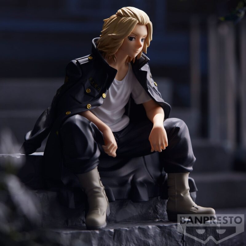 Vue 3/4 de face à mi-distance de la figurine de Manjiro Sano de Tokyo Revengers en manteau noir, assis et pensif.