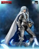 berserk-figurine-grifith-reborn-band-of-falcon-three-zero_17 Vue 3/4 de face à mi-distance de la figurine de Griffith de Berserk en armure argentée avec une cape, tenant un insigne doré.