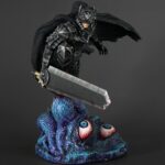 Vue 3/4 de face à mi-distance de la figurine d'un guerrier en armure, tenant une grande épée, présentée dans une boîte.