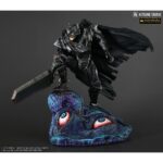 Vue 3/4 de face à mi-distance de la figurine de Guts de Berserk en armure noire, tenant une grande épée ensanglantée, sur la tête d'une créature.
