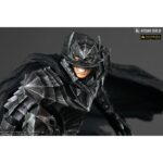 Vue 3/4 de face en plan rapproché de la figurine de Guts de Berserk en armure usée, avec une expression agressive.