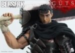 Vue 3/4 de face en plan rapproché moyen de la figurine de Guts de Berserk en armure usée, tenant l'épée Dragon Slayer.