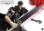 Vue 3/4 de face à mi-distance de la figurine de Guts de Berserk en armure sombre avec une cape, tenant une épée ensanglantée.