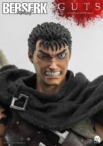 Vue 3/4 de face à mi-distance de la figurine de Guts de Berserk en armure sombre avec un manteau.