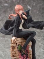 Vue 3/4 de face à mi-distance de la figurine de Makima de Chainsaw Man, en costume noir avec manteau, assise sur des briques.
